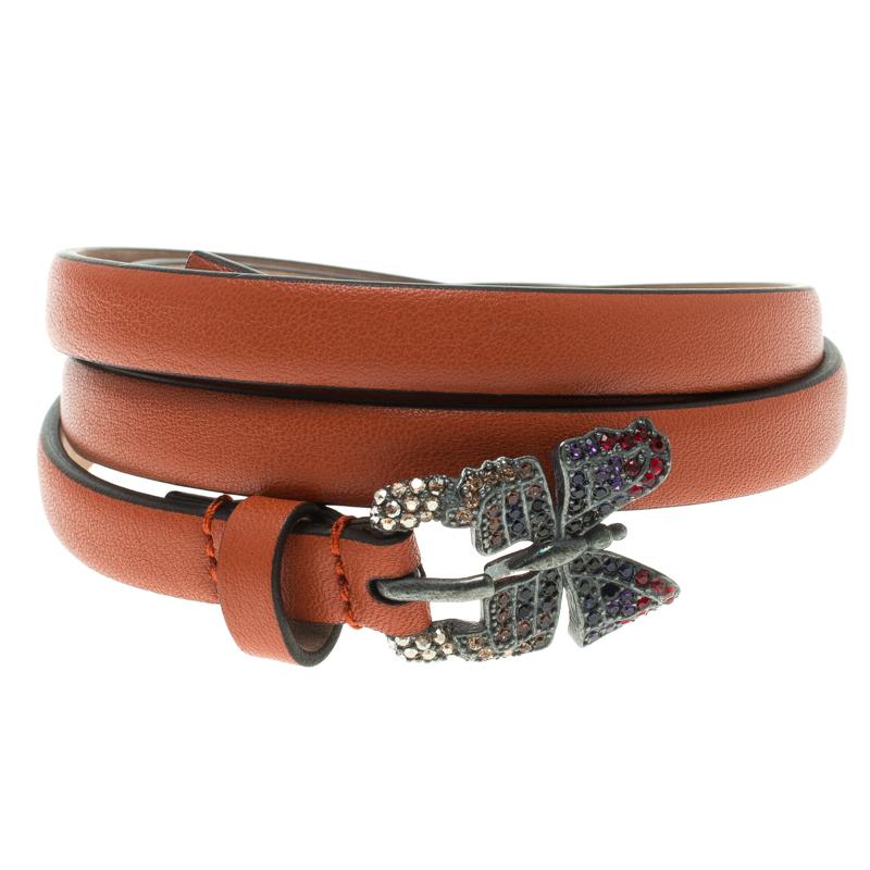 Accessorise like a fashionista using this Buckle Belt by Valentino Garavani. The piece is crafted from quality leather in a catchy orange hue and completed with a gorgeous silver-tone butterfly buckle that is embellished with tiny crystals. This is