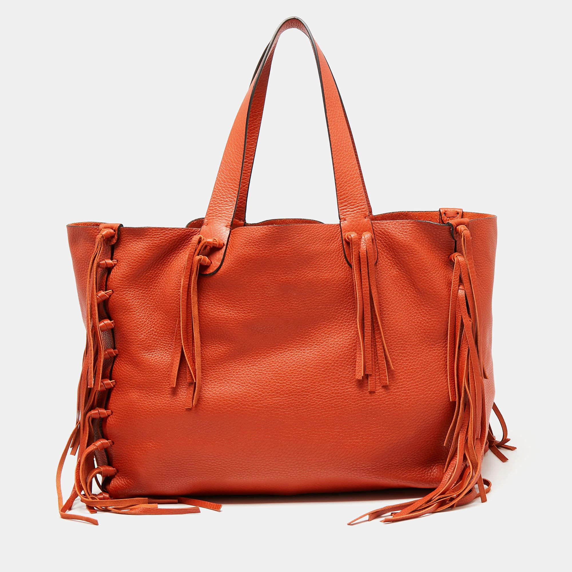 This Valentino C-Rockee tote embodies the perfect balance between art and utility. An ideal everyday accessory, it is elevated with eye-catching features and practical elements. Its construction is highlighted with tied fringed knots on both the