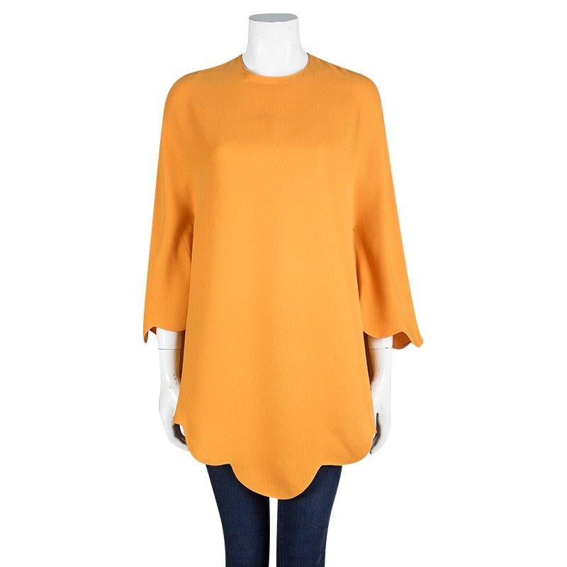 We are in love with this poncho from Valentino as it is brimming with freshness and style. Made from silk, it flaunts a vibrant orange hue with a back zipper and a beautifully scalloped hem. Your wardrobe truly deserves a creation as fine as this