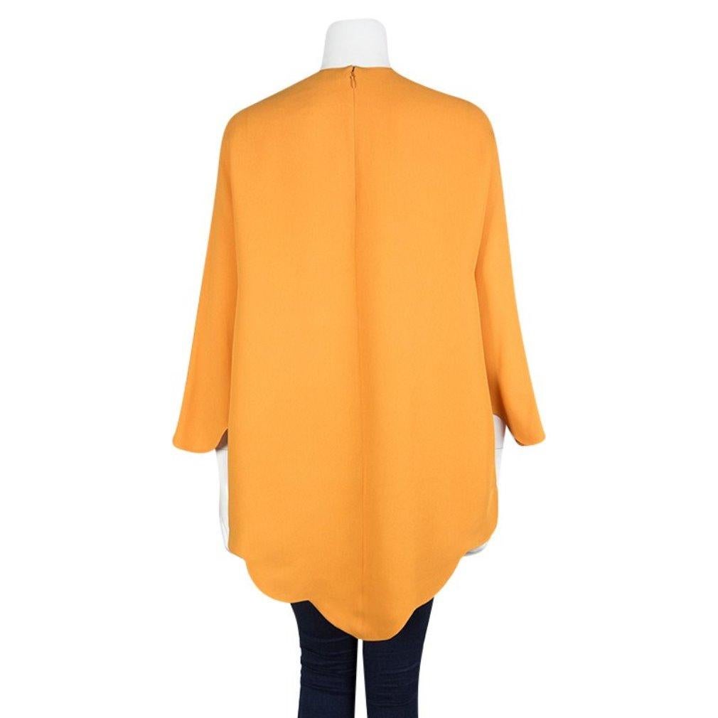 We are in love with this poncho from Valentino as it is brimming with freshness and style. Made from silk, it flaunts a vibrant orange hue with a back zipper and a beautifully scalloped hem. Your wardrobe truly deserves a creation as fine as this