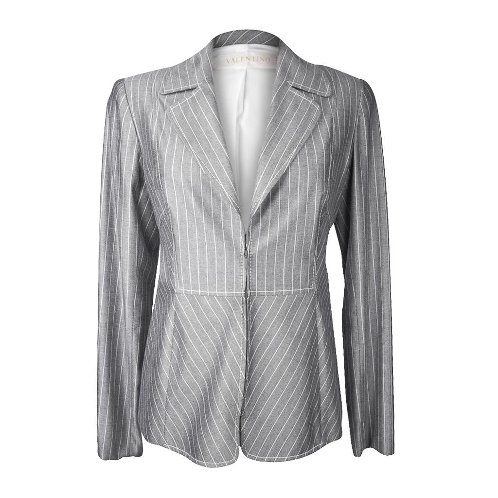 Guaranteed authentic Valentino beautiful gray and white pinstripe fabric.
Single breast with a hidden front zipper and a notch lapel.
Stitch detail creates shape and interest.
Cuff detail with single non working button.  
Jacket is fully lined in