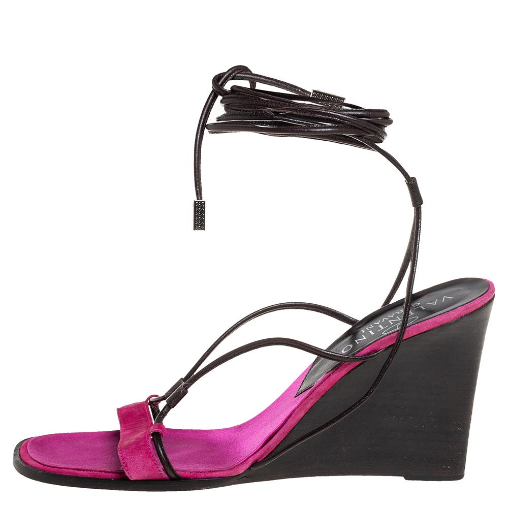Keep your comfort at a maximum with these beautiful suede and leather sandals from Valentino. Look simple yet chic in this pair of pink sandals designed exclusively for you. These sandals are fitted with ankle wrap fastenings, wedge heels, and