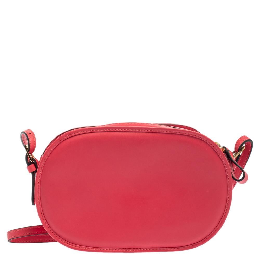 This pink crossbody bag from Valentino impresses with a leather construction that exhibits a brand logo stitch detailing on the front and a top zip closure in gold-tone. The leather-lined interior offers decent space to hold your essentials while