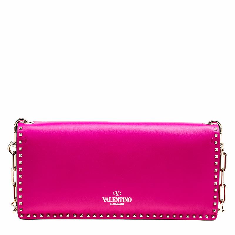 Catch admiring glances when you carry this Micro Rockstud clutch from Valentino! Crafted from pink leather, the bag has a structured shape and a long, chain-link shoulder strap. The bag features the iconic Valentino Rockstuds outlining the bag in a