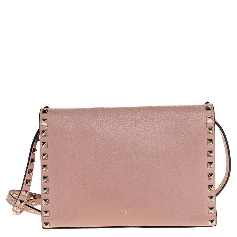 This gorgeous Valentino bag has been crafted in pink leather. The exterior features Rockstud detailing in gold-tone on the strap as well as on the bag. With a flap closure, the bag opens to a suede-lined accommodating interior that can hold all your