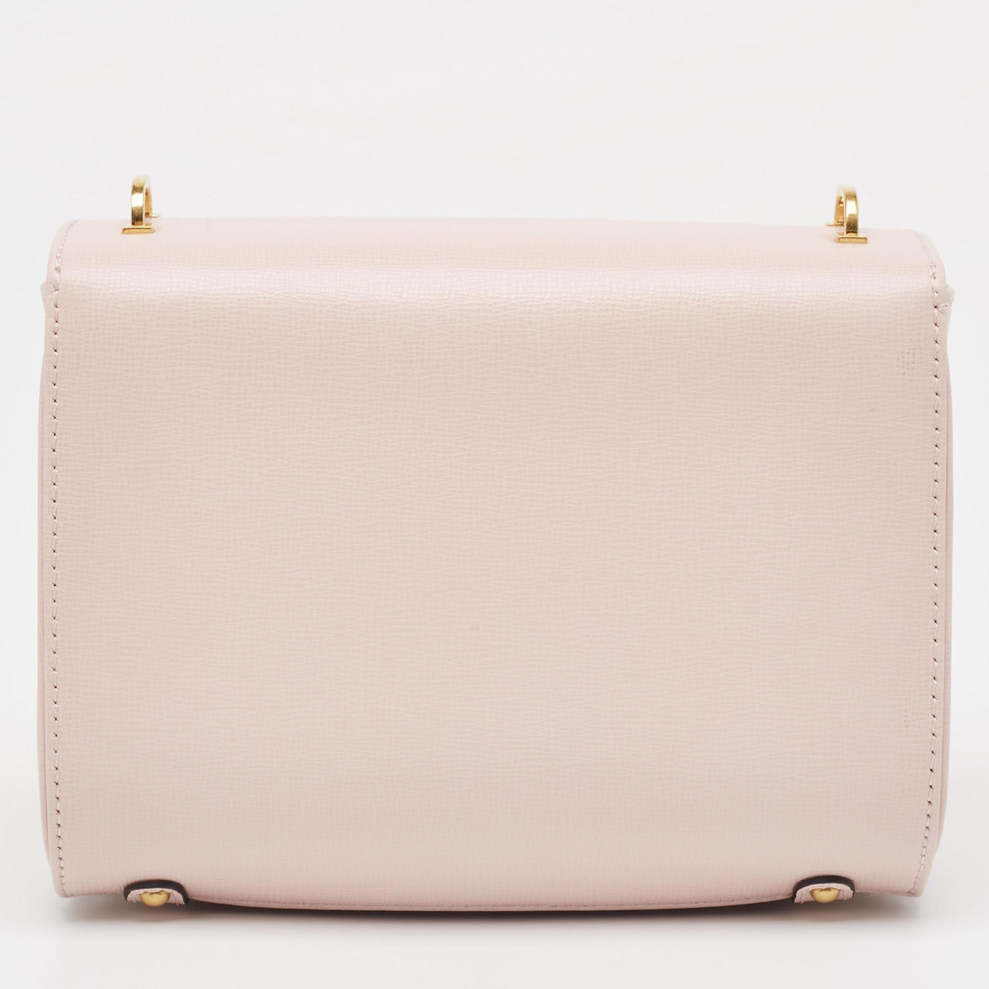 The Valentino bag exudes elegance with its soft pink hue and luxurious leather construction. Adorned with the iconic VLogo hardware, it features a flap closure for security and a spacious interior, making it both chic and practical for everyday