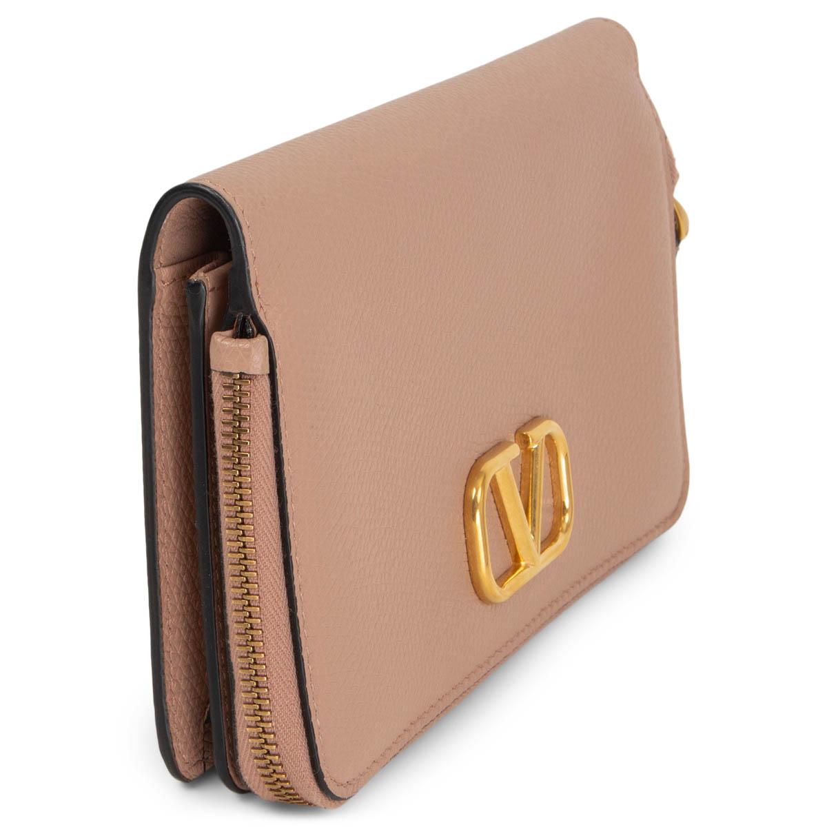100% authentic Valentino V Logo wallet in Rose Cannelle (nude pink) grained calfskin with gold-tone metal hardware. Opens with a zipper to a big coin pocket lined in nude nylon. The other compartment opens with a push-button and is lined in smooth