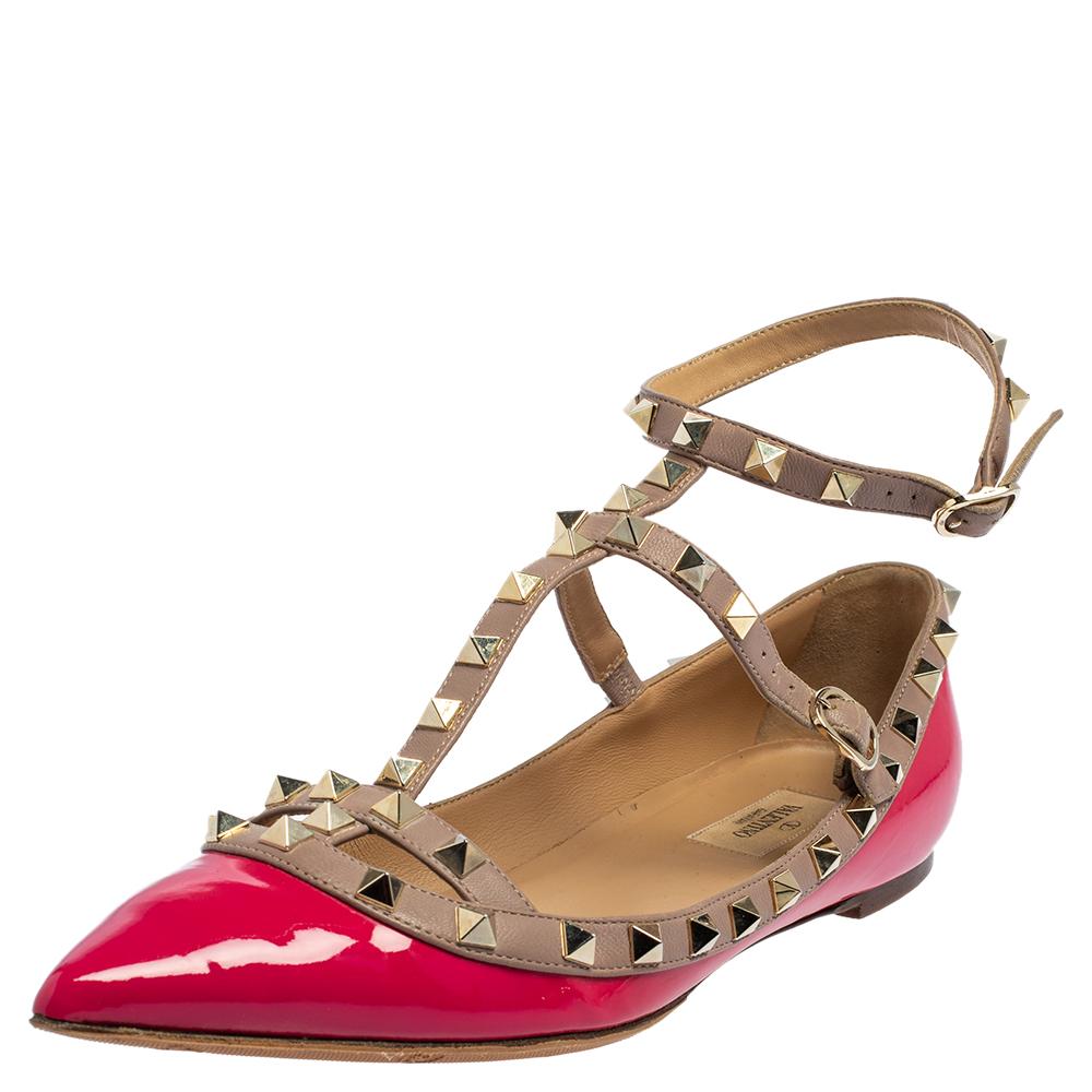 Valentino Rockstud ballerina in pink patent leather. The flats feature pointed toes, buckle fastening, and signature studs on the beige straps.

