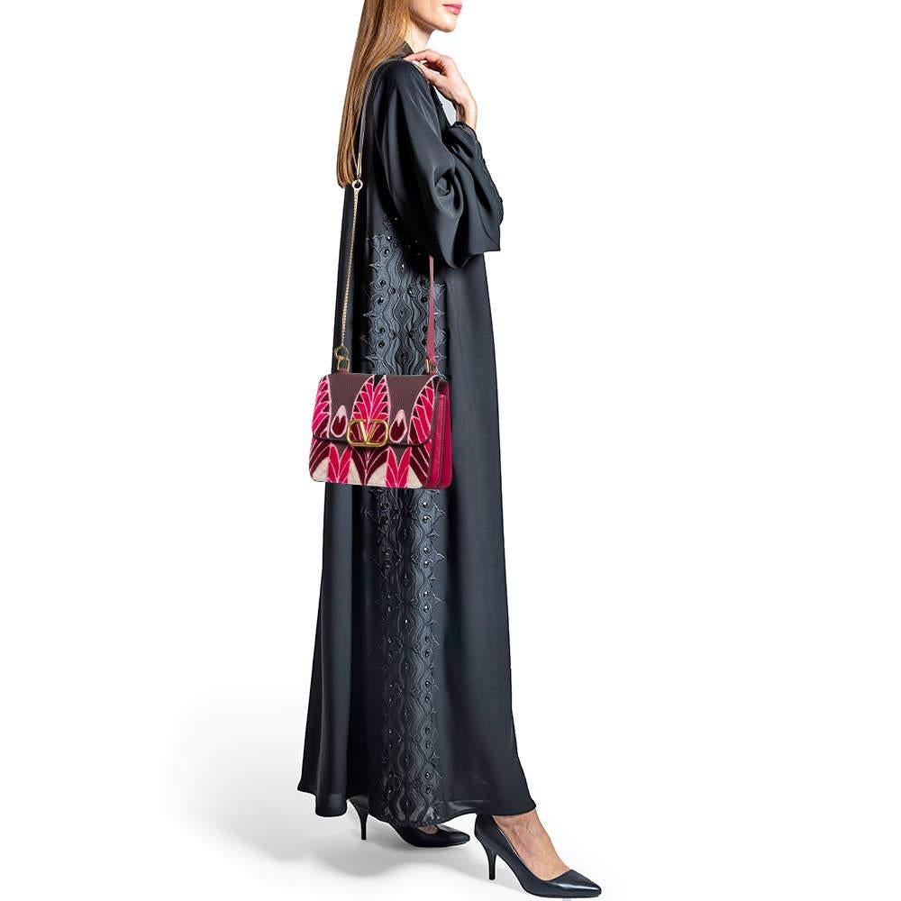 Crafted from sumptuous pink and plum leather this Valentino VSling Shoulder Bag features exquisite velvet embroidery. Its adjustable strap and sleek gold tone hardware add a touch of luxury making it a perfect blend of style and functionality for