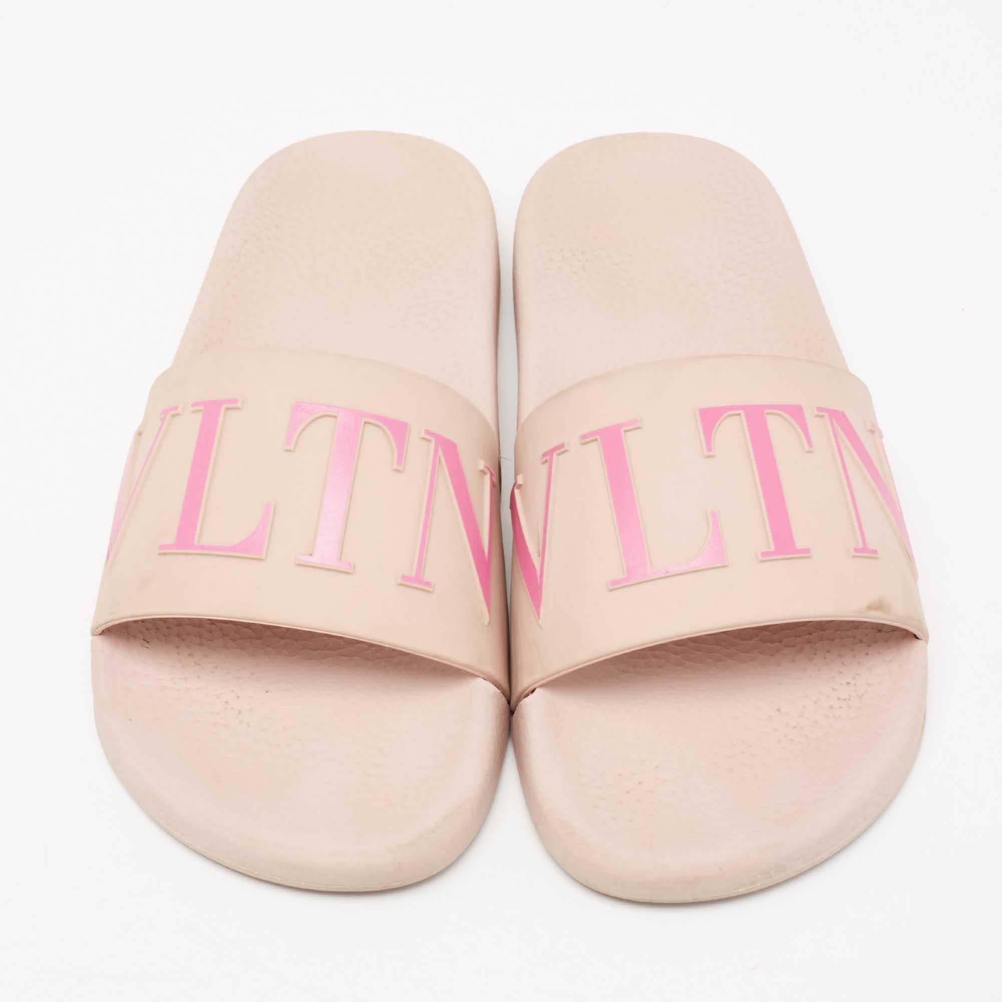 Comfort and style come together with these slide sandals from Valentino! The pink slides are crafted from rubber and feature an open-toe silhouette. They flaunt VLTN lettering on the vamp straps and are sure to make your feet very happy!

Includes: