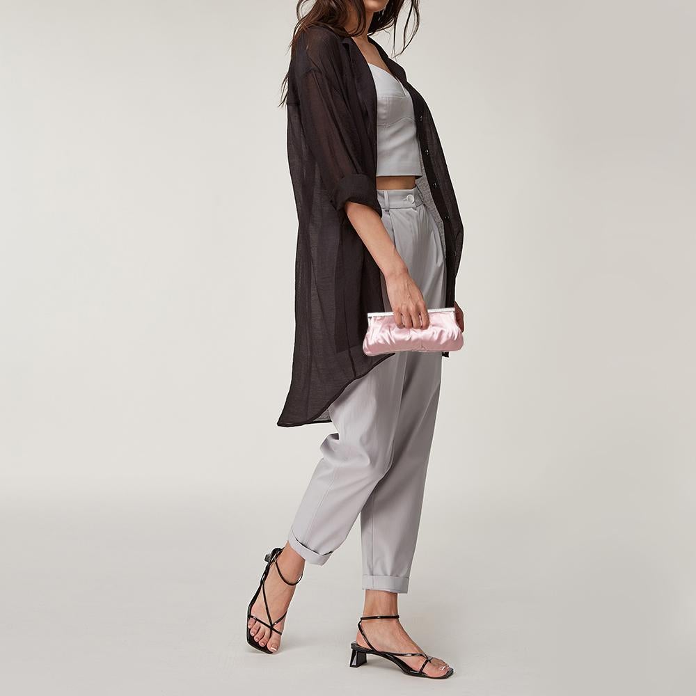 Squisita, incantevole ed eterea, questa clutch di Valentino merita un posto speciale nel tuo guardaroba! La creazione rosa è realizzata in raso e presenta cristalli scintillanti impreziositi sulla parte superiore. La chiusura superiore si apre su un