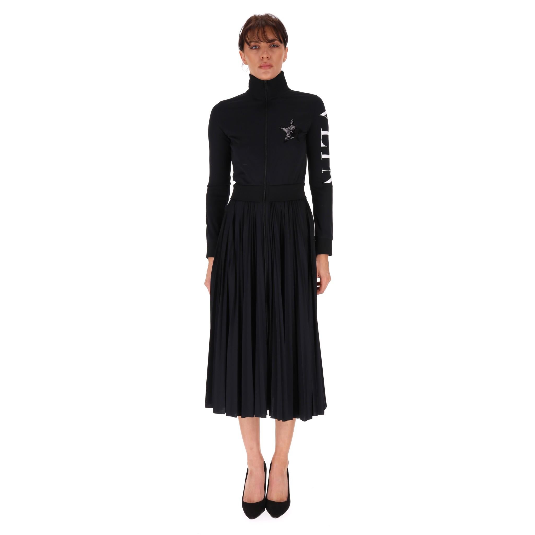 Valentino Pleated Logo Dress

Black dress with sporty, fitted top detailed with 'VLTN' logo in white along the sleeve and tonal sequin star embellishment to the chest.

High neck with centre zip closure and pleated midi skirt.

Rrp £1,800

Size –