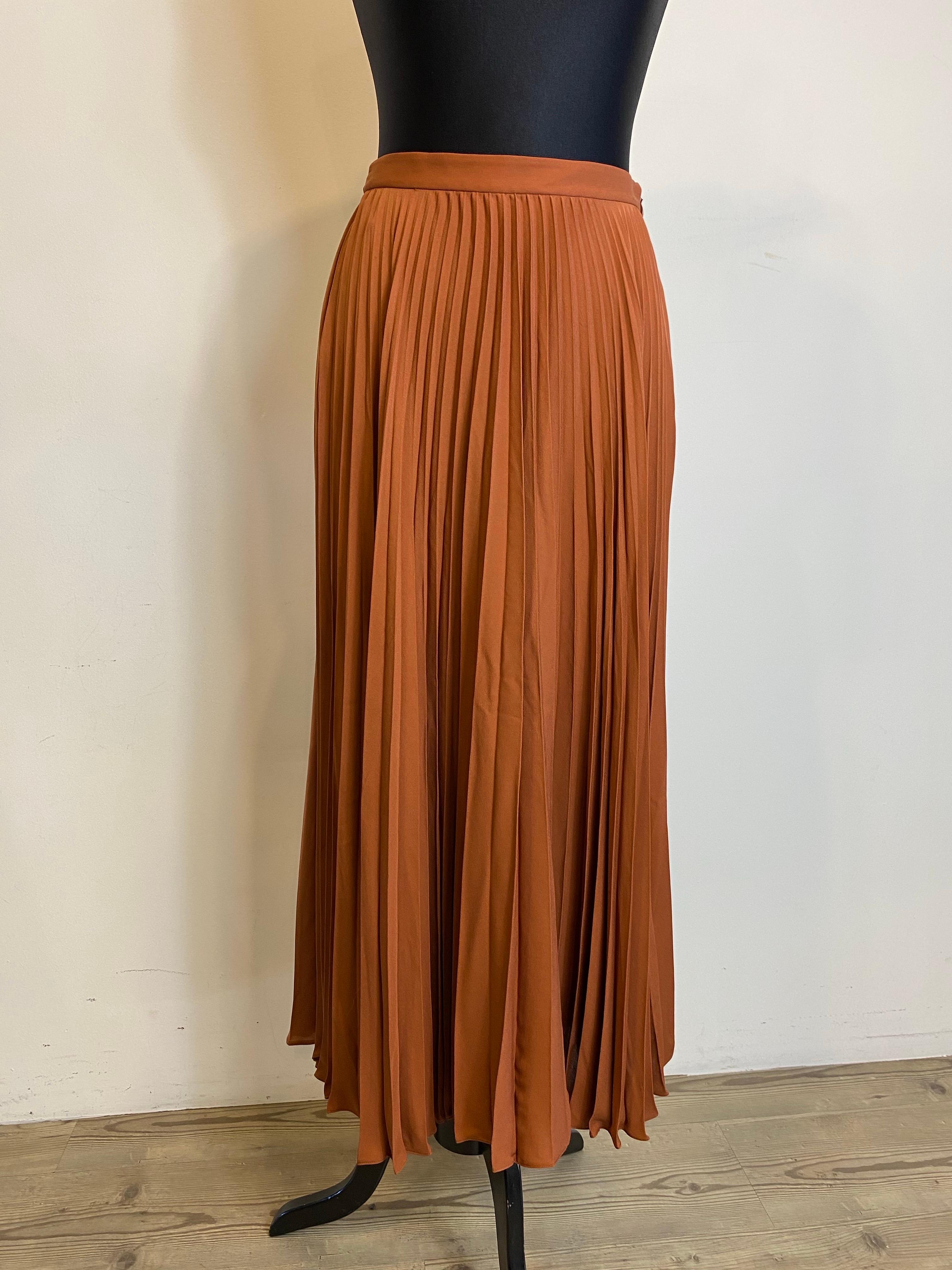 Gonna a pieghe di Valentino in 100% seta, colore biscotto leggermente più scuro di quello della foto.
Zip laterale.
Taglia 40 (IT).
Vita 34 cm
Lunghezza 90 cm
Presenta alcuni segni di usura ma è in ottime condizioni.