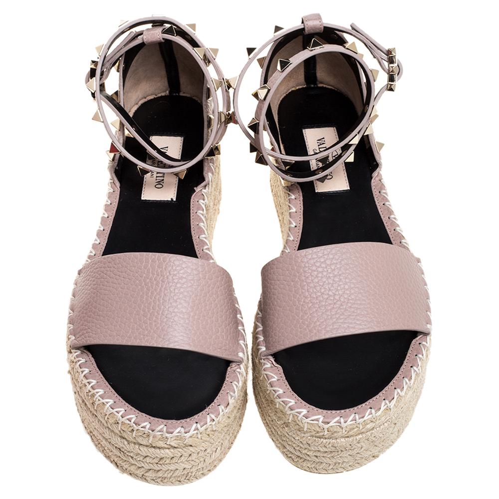 Designed purposely for fashion queens like you, these Valentino espadrille sandals are leather-made and feature ankle wraps, braided wedges, and their signature Rockstud accents. To look your best, wear the pair with culottes and a cropped