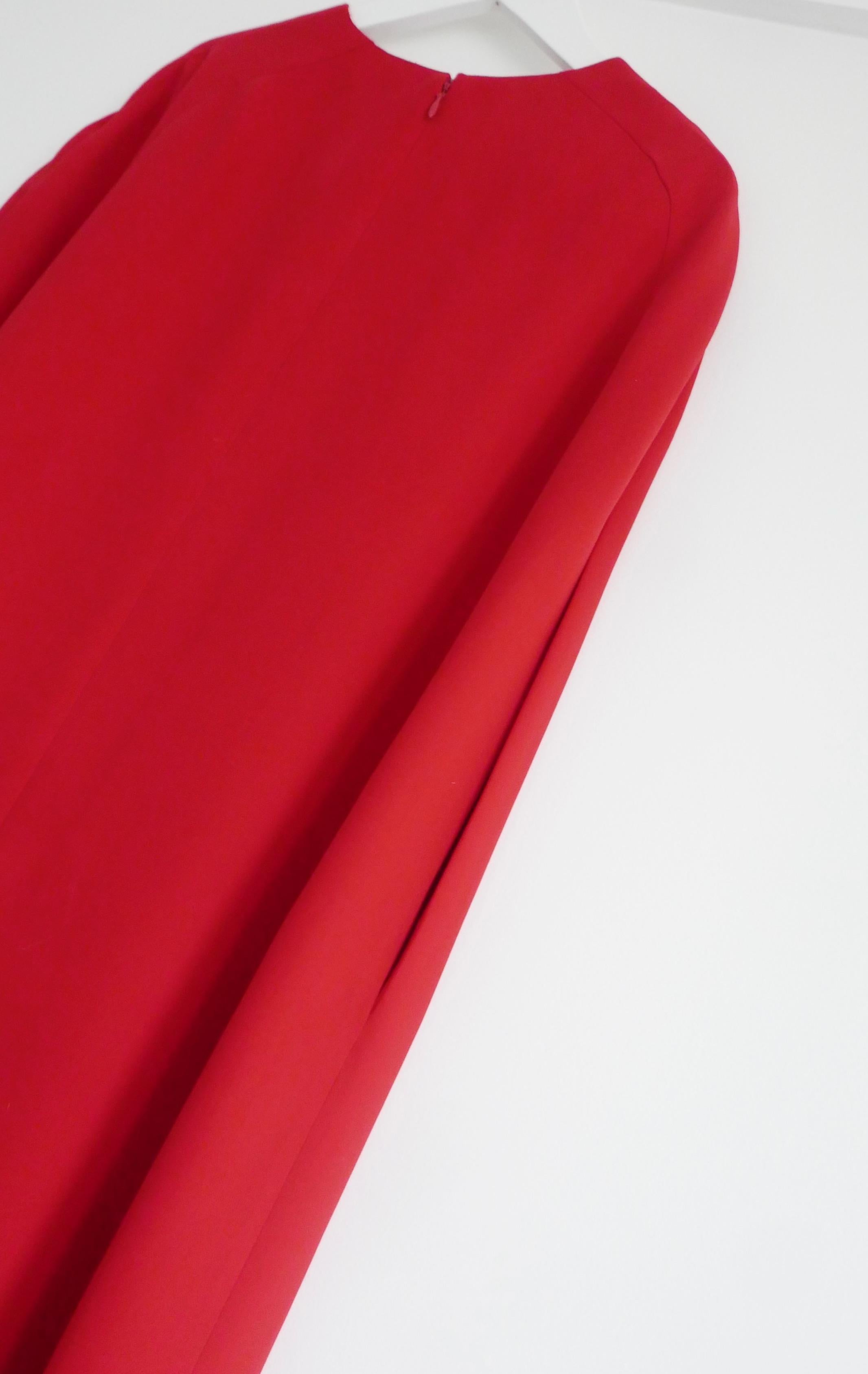 Iconic Valentino red cape dress from the Pre-Fall 2014 collection. Has been newly dry cleaned. Made from the label’s signature vivid ‘Valentino Red’ silk crepe, it has a dramatic minimalist cape inspired cut with deep arm slits and floor length hem.