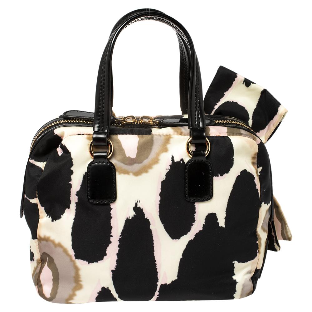 A fresh take on femininity, this Valentino Boston bag is a must-have piece to project a chic look. Crafted from nylon and leather, it features a stunning print and an exaggerated bow. Secured with zip closure, the bag is held by dual