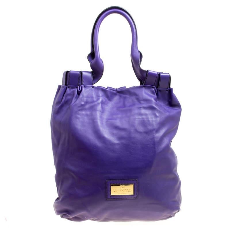 Diese lilafarbene Shopper-Tasche von Valentino besticht durch ihr modernes Design und ihren Stil. Die hübsche Petale-Tasche ist aus Glattleder gefertigt und mit schönen Blumendetails auf der Vorderseite versehen. Sie verfügt über zwei Henkel an der