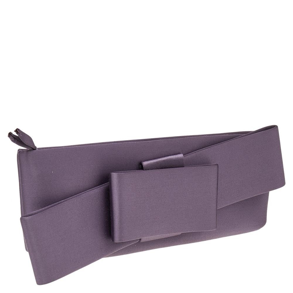 Bold, yet feminine, this clutch by Valentino is what you want to carry on an evening out. The purple satin exterior is simply detailed with a lovely oversized bow and a top zip closure. Its open interior is also lined with satin.