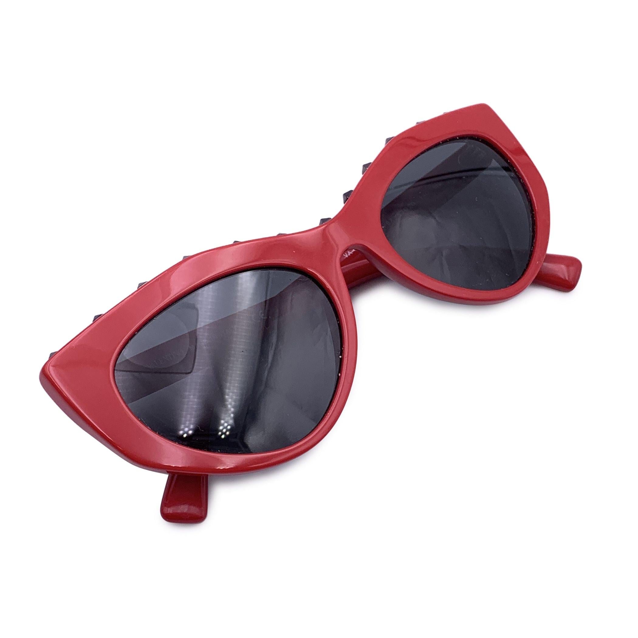 Valentino Cat eye Sunglasses, Model 'Soul Rockstud - VA 4060'. Red acetate frame with gunmetal studs on top. Cat-eye design. Valentino signature on the top. Original grey lenses. Mod & refs: VA 4060 - 5110/87 - 53/20 - 140 - 3N. Made in Italy