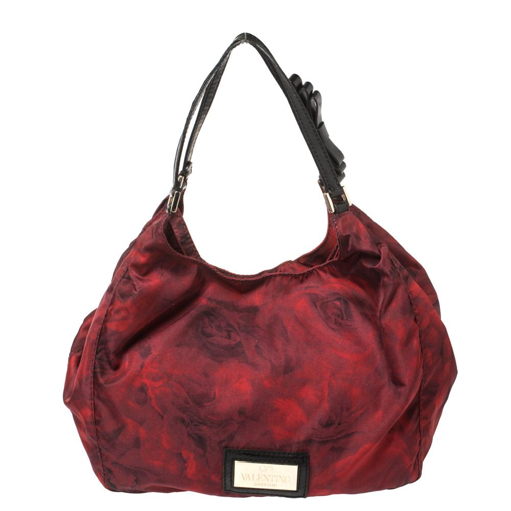 Elevate your style with this gorgeous shoulder bag by Valentino. Crafted from rose-printed nylon, the bag features a distinctive bow detail, two handles, and a satin-lined interior. It is lightweight, durable, and stylish.

