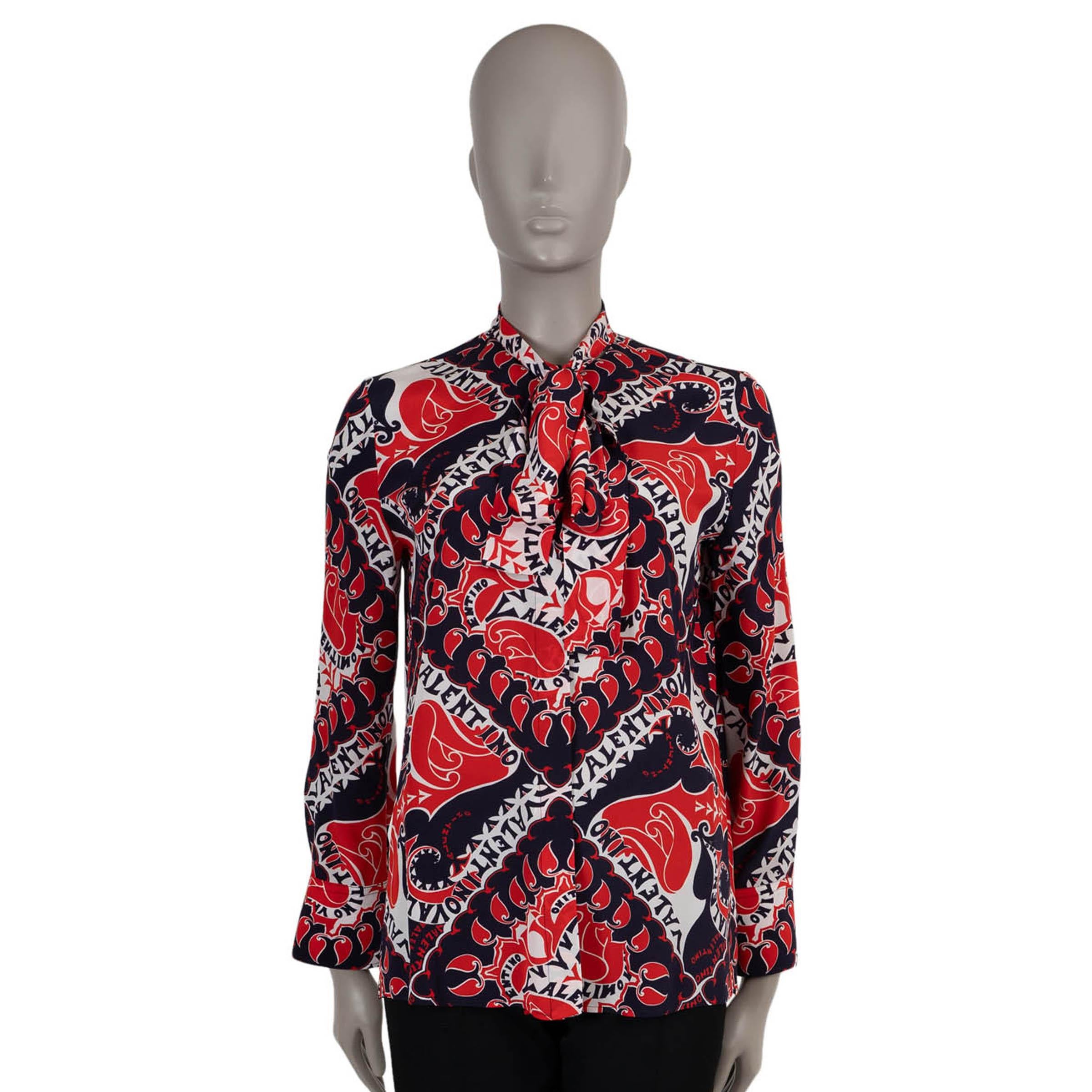 This 100% authentic Valentino blouse in red, navy, and white Manifesto printed crêpe de chine silk (100%) blends bold graphics with timeless elegance. Designed with a relaxed silhouette, it features a refined tie-neck detail that adds a touch of