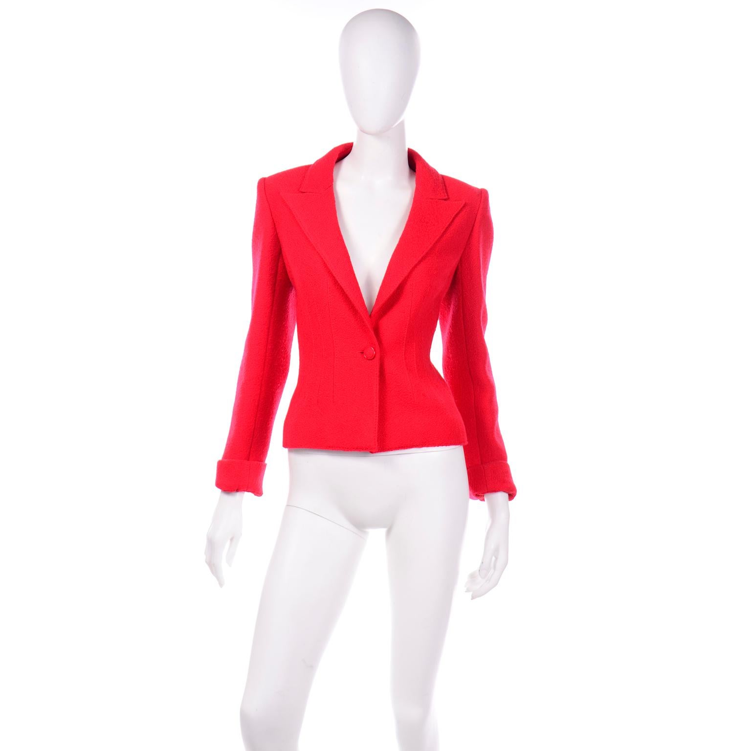 This is an incredible red wool bouclé style blazer or jacket designed by Valentino. There is a single fabric covered button center closure with several darts along the front of the waistline. The lapel is pointed and the shoulders are structured