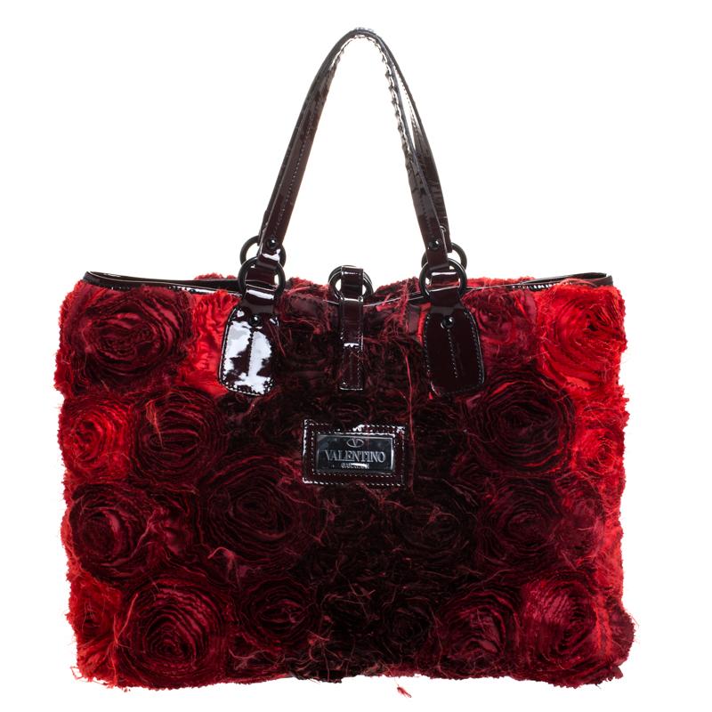 Valentino is known to bring out unique and one-of-a-kind pieces year after year and this bag is indeed one of them! It is crafted beautifully using satin flowers and patent leather trims. It comes equipped with dual handles and a satin-lined