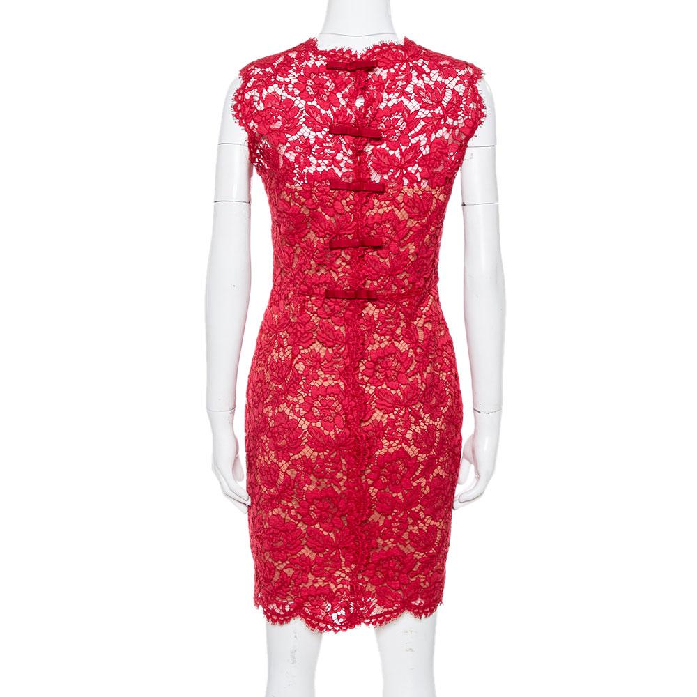 This stylish and chic dress by Valentino is perfect for special occasions and evenings. Crafted from intricate lace, it carries a striking hue of red and has a sleeveless silhouette. The sheath dress has a high neckline, scalloped edges along the