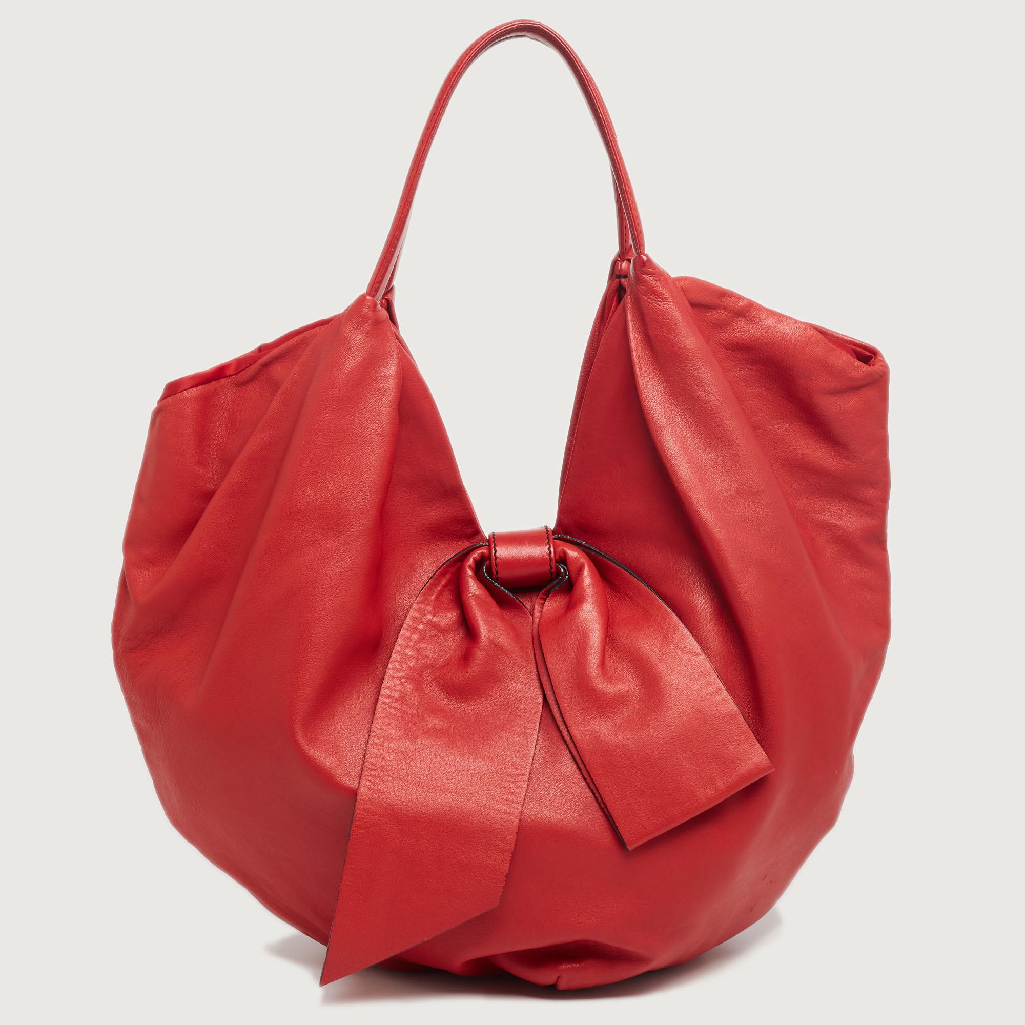 A large bow on the front is the highlight of this Valentino 360 Bow hobo. It is crafted using red leather and equipped with two handles and a spacious satin interior. This eye-catching bag will add a chic finish to your favorite looks.

Includes: