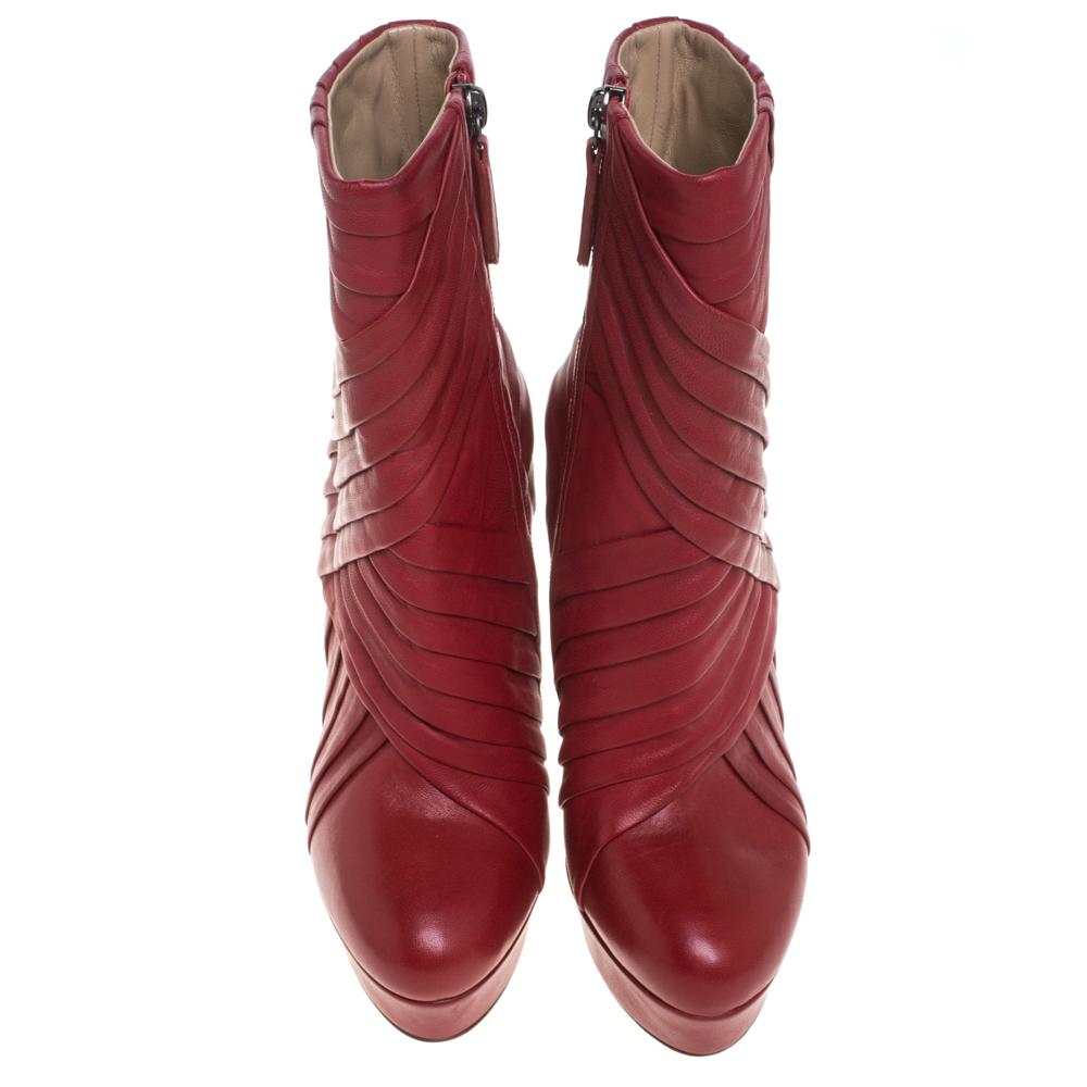 Grab these striking boots that hail from the house of Valentino! Red in color and styled with towering heels, they are detailed with pleat detailing. Crafted from quality leather, they are equipped with 13.5 cm heels, platforms, black-tone hardware,
