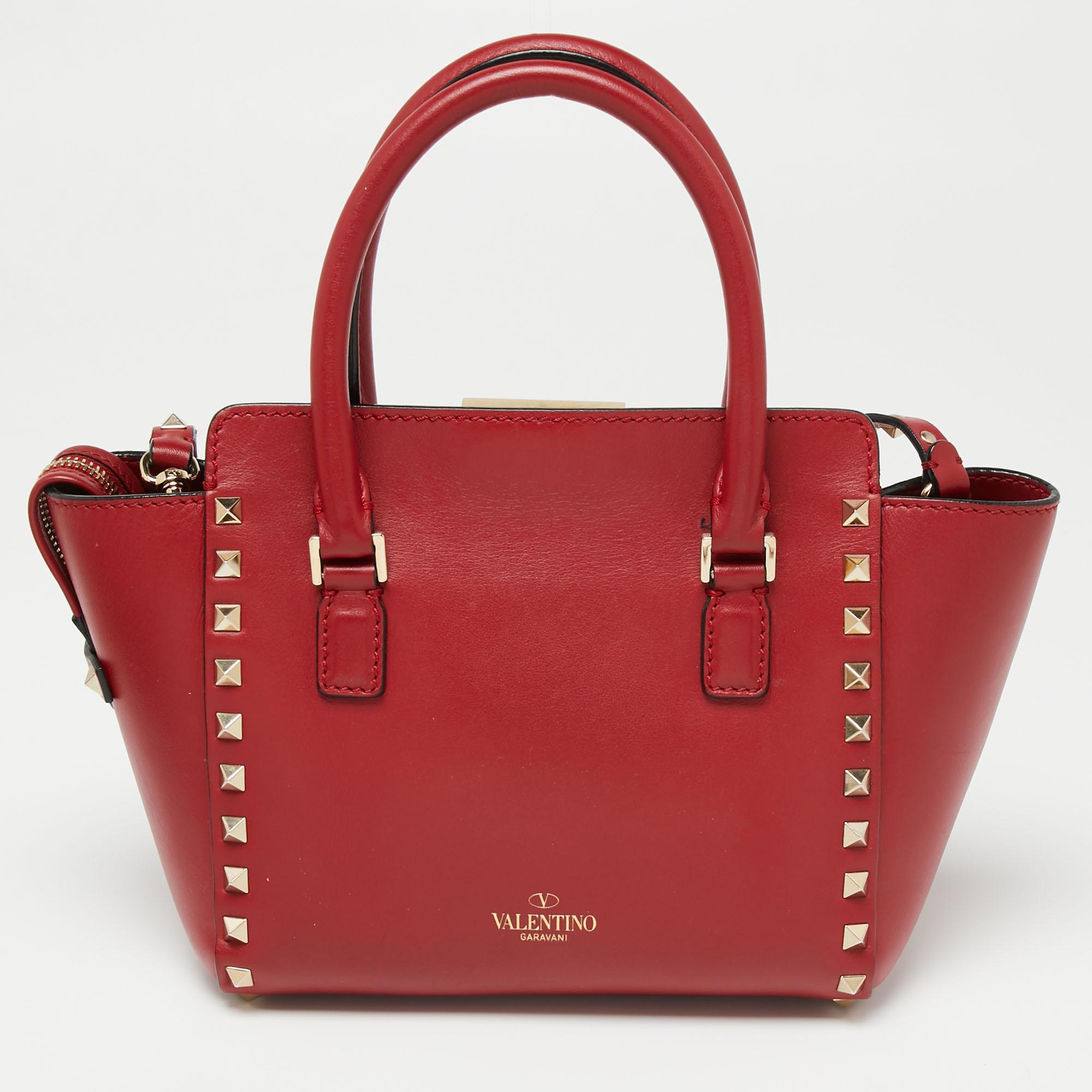 This gorgeous tote from the House of Valentino brings you endless practicality, style, and luxury. It is fashioned in red leather and is augmented with the iconic Rockstud embellishments. It is enhanced with dual handles, a spacious fabric-lined