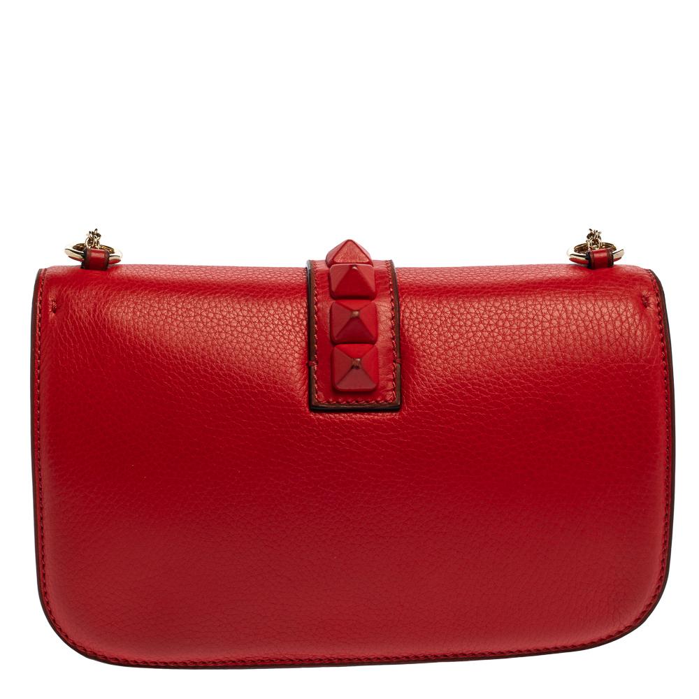 If you are looking for a bag with a blend of modern style, glamour, and class, this Valentino creation is the answer. Crafted from leather in a red shade, this piece comes with a slender chain strap and a flap with a push-lock to secure the
