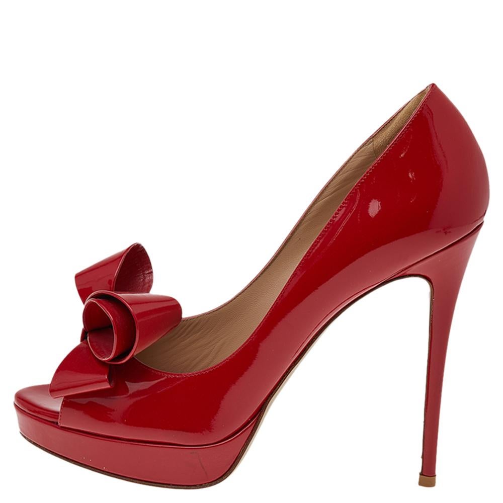 Create an aura of elegance with these stunning peep-toe pumps from Valentino. These red pumps are crafted from patent leather. The pair flaunts couture bow detailing on the uppers, leather-lined insoles, solid platforms, and 16 cm heels.

Includes: