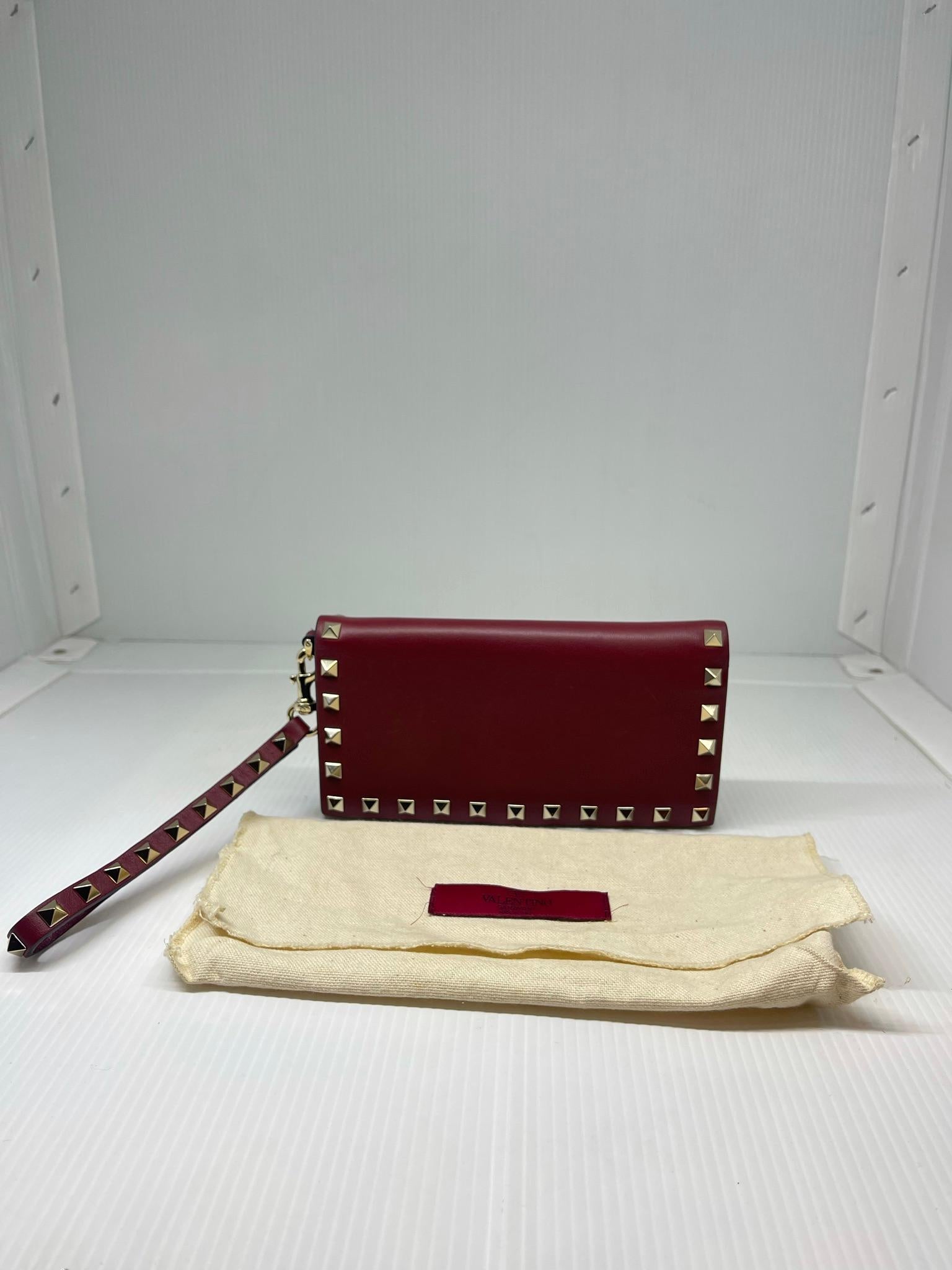 Beautiful valentino rockstud wristlet clutch in red leather. Light gold hardware. Overall in great condition with minor scuffs on the leather surface. Comes with its dust bag and removable strap.