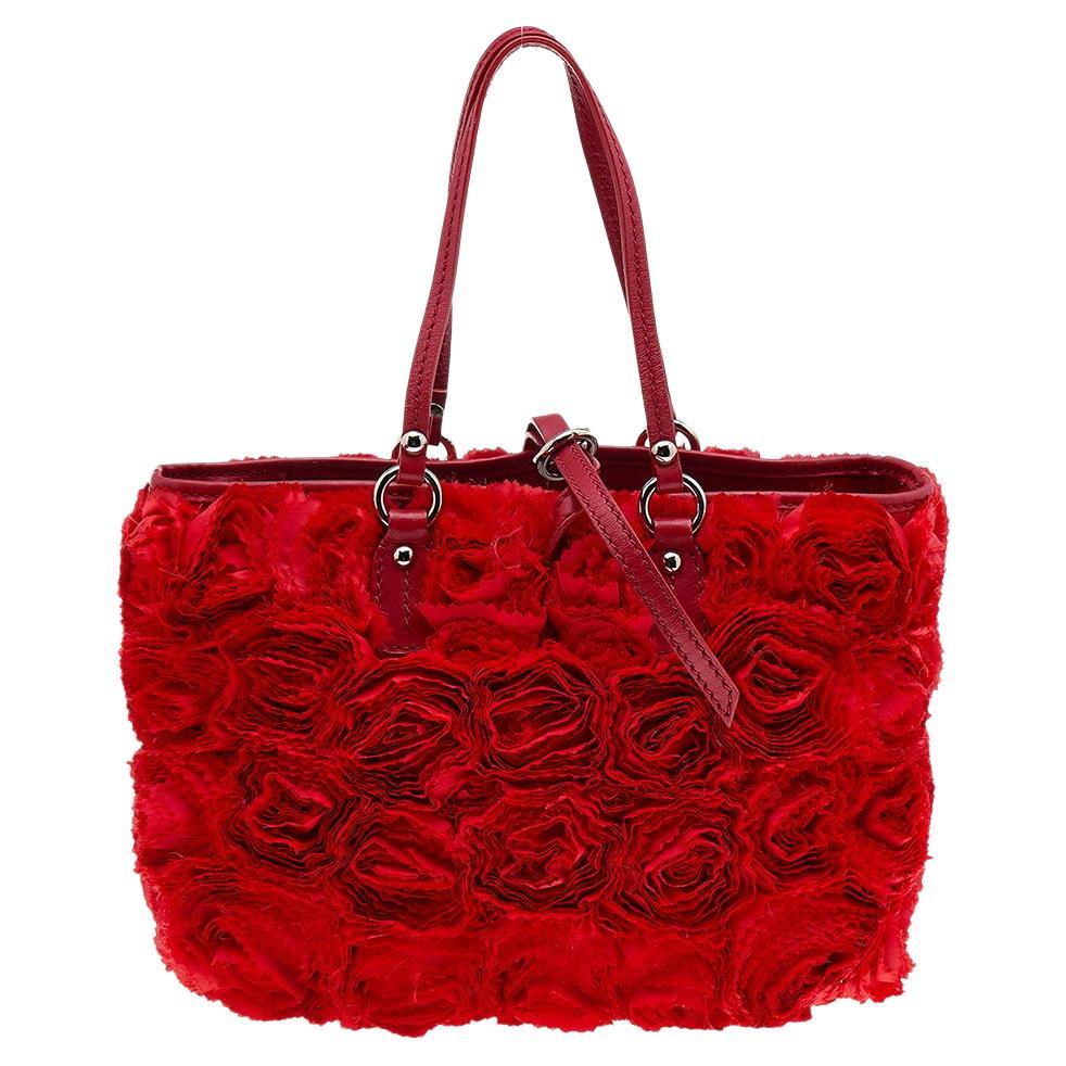 Step out fashionably with this stunning Valentino tote from the beautiful Rosier collection. This unique bag has been crafted using silk as well as leather and is covered in floral appliqués. The bag is complete with dual handles and a spacious