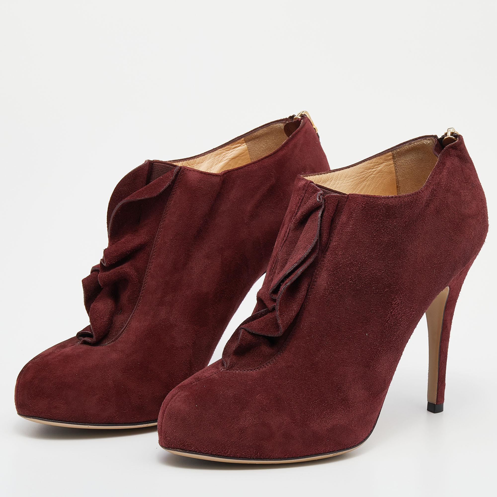 Made in Italy, this pair of Valentino ankle booties is beautifully designed with red suede. The shoes have covered toes, ruffle trim & elastic insert on the uppers, and simple zipper fastenings on the counters. The slim heels give the design a grand