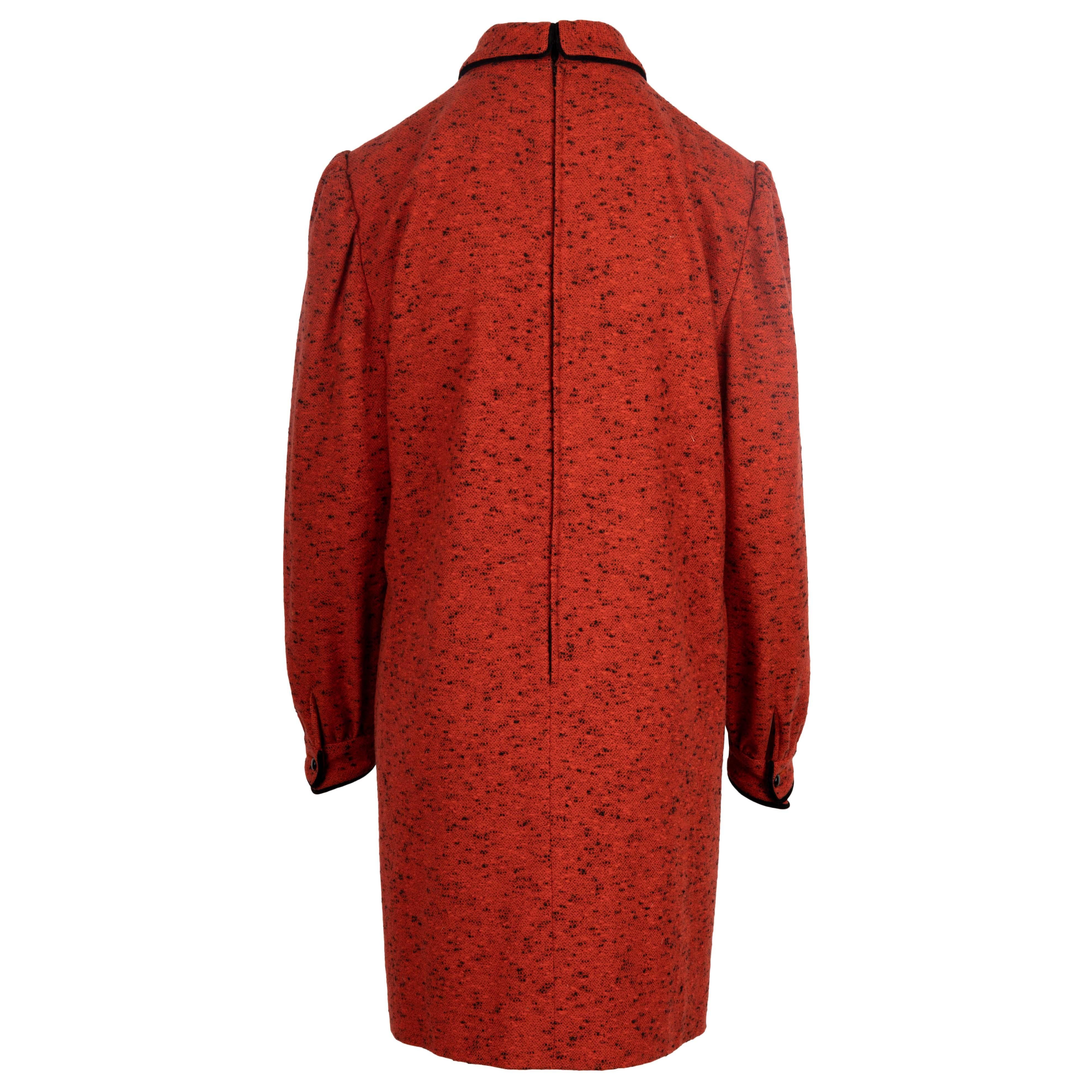 Das rote, langärmelige Kragenkleid von Valentino ist aus roter und schwarzer Mélange-Wolle gefertigt und mit einer Schleife aus schwarzem Samt sowie Ärmelmanschetten mit einer kleinen Raffung an der Schulter und der Manschette versehen. Der Haken an