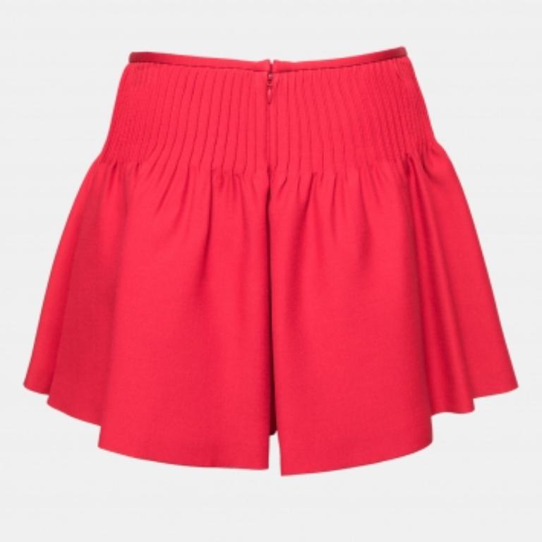 Estos pantalones cortos proceden de la emblemática casa Valentino. Confeccionados en lana y seda, lucen un precioso tono rojo. Son geniales para un día libre o unas vacaciones. Combínalo con una camiseta sencilla y unas sandalias.