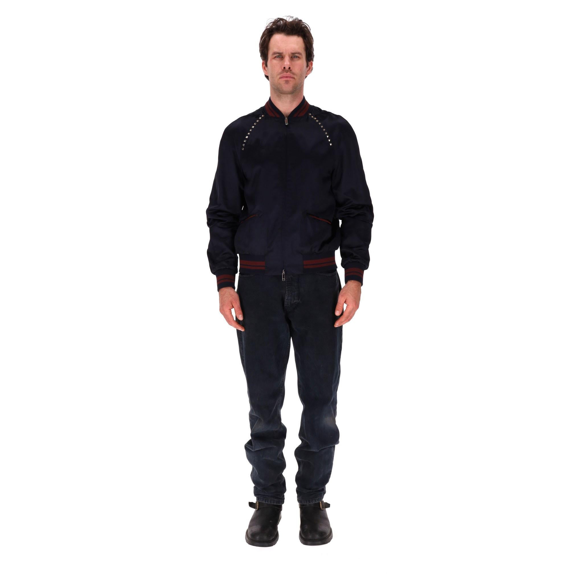 Valentino Rockstud Bomber Jacket

Navy bomber jacket detailed with the brand's signature gold Rockstuds embellishment.

Ribbed collar, cuffs and hem with red stripe pattern, zip fastening along the centre and welt pockets to the side.

Rrp Approx.