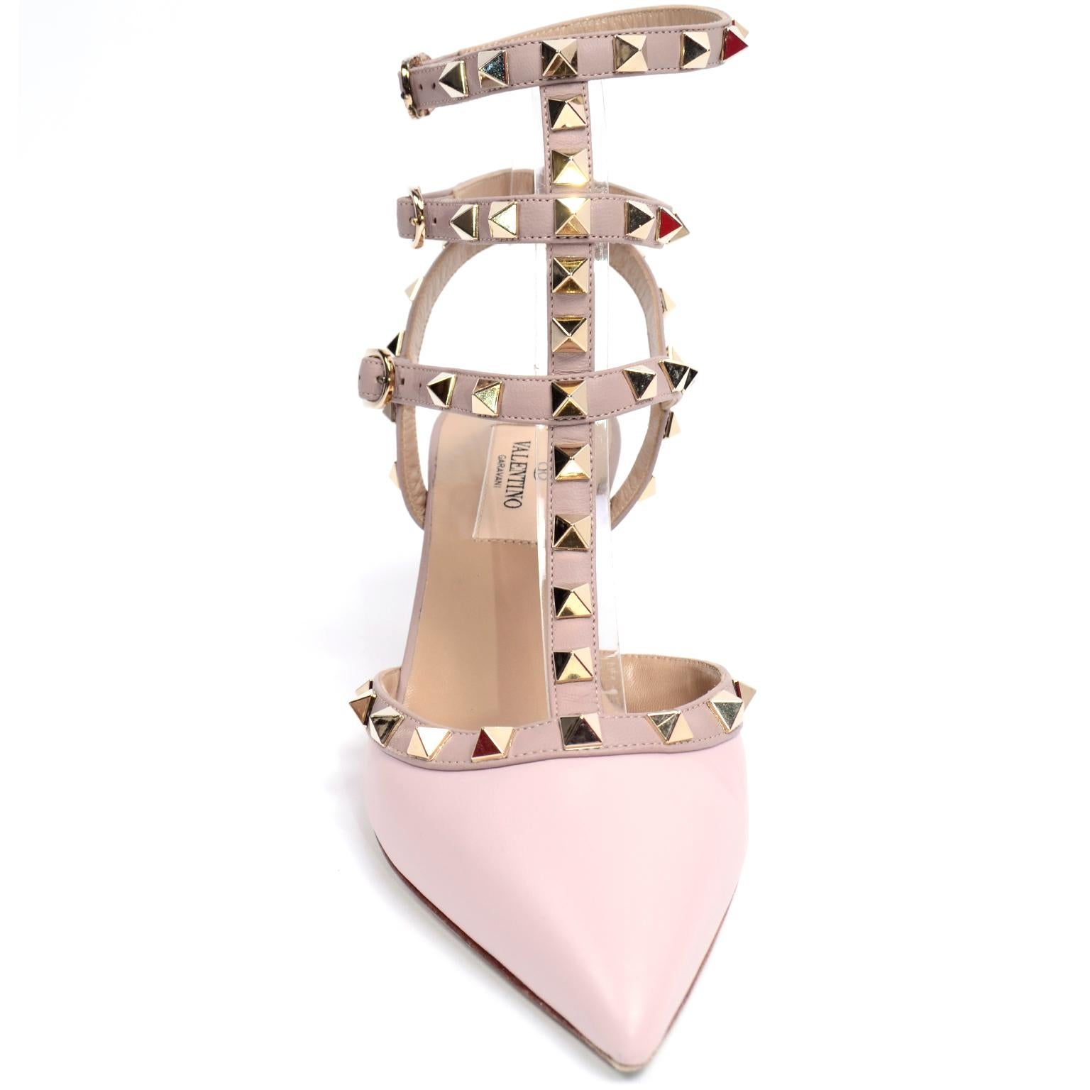 These gorgeous Valentino rockstud shoes are in a lovely pink and beige leather and feature side buckle fastenings, a pointed toe, a branded insole and low heel. The gold-tone Rockstud embellishments are a Valentino signature that toughen up an