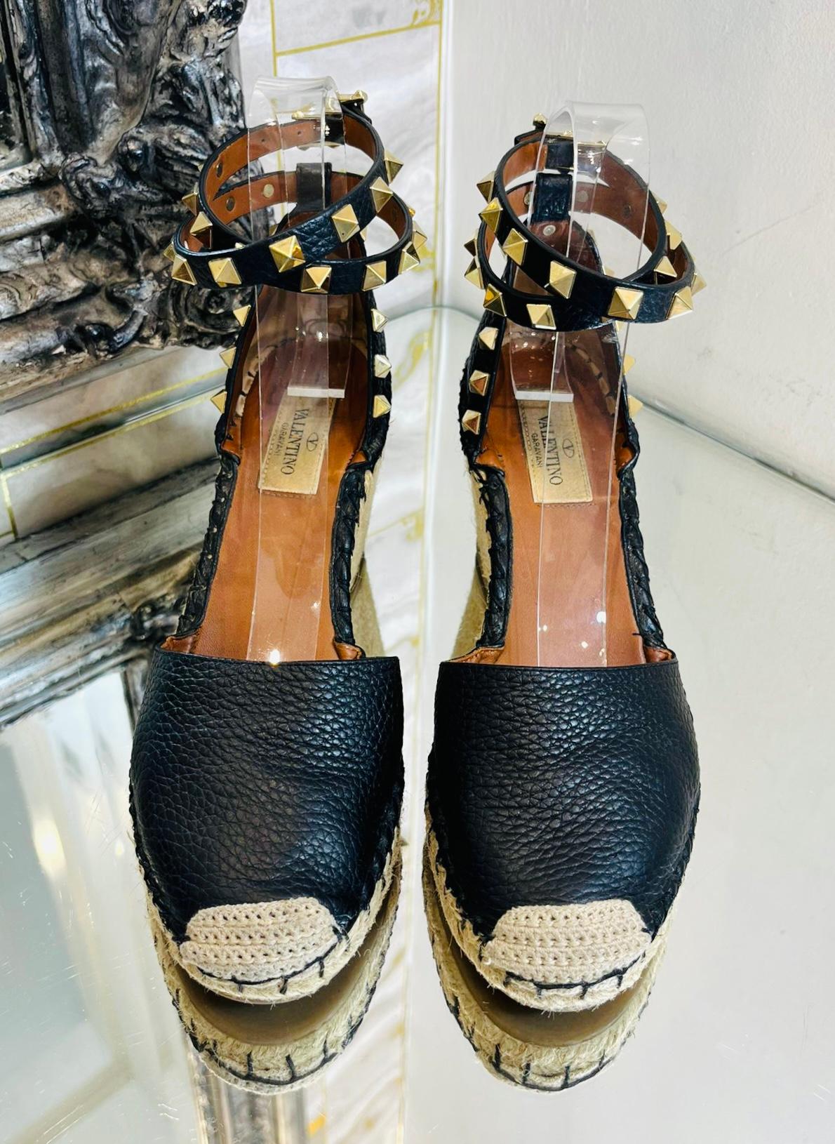 Valentino Rockstud Double Leather Espadrilles

Black sandals crafted from textured leather and set on a lightweight jute wedge.

Detailed with the brand's signature hand-placed gold pyramid studs.

Featuring double ankle strap with buckle closure