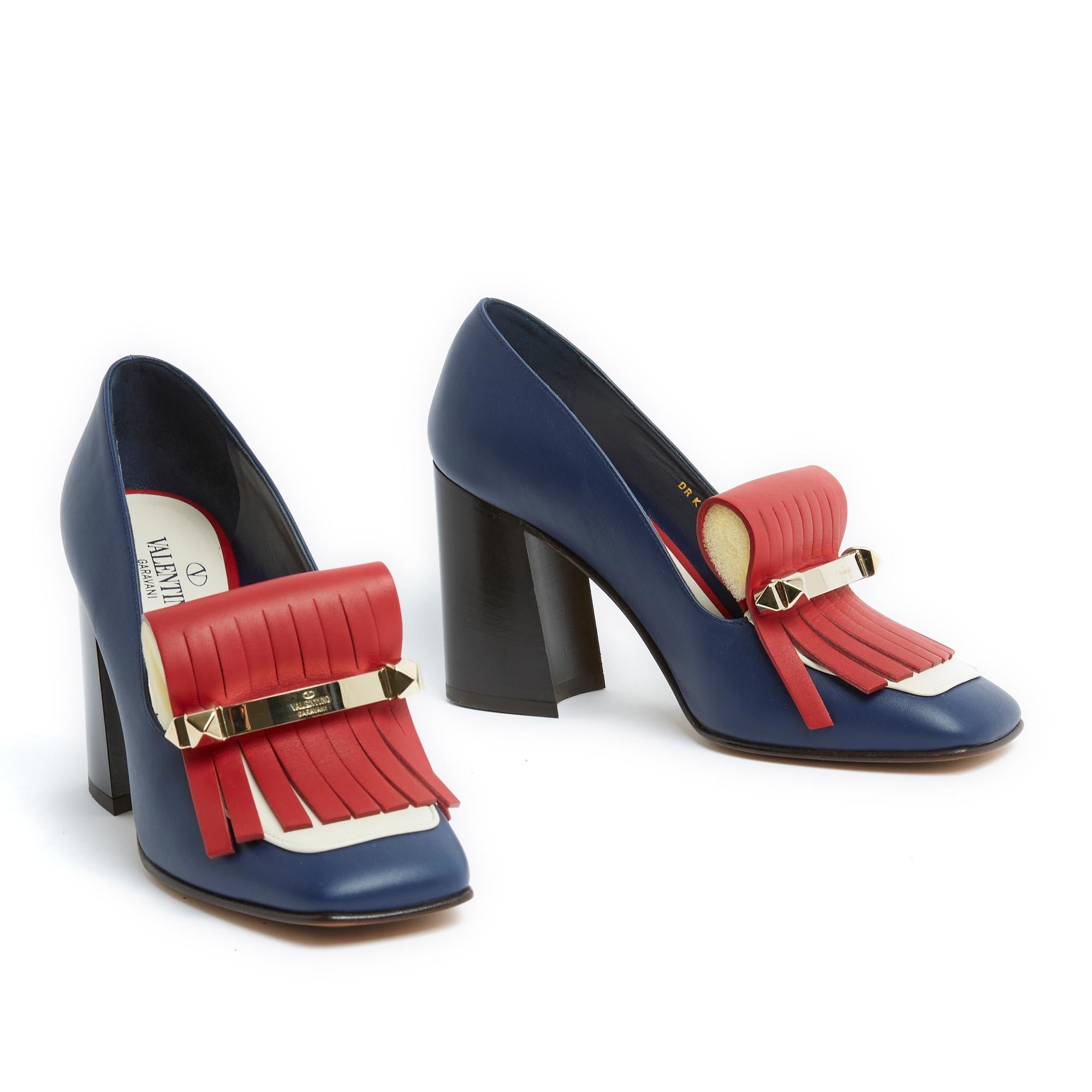 Valentino Garavani Rockstud series pumps in tricolor navy blue, red and ecru leather, branded barrette in rose gold-tone metal, wide heel covered in black leather. Size 38EU: heel 9 cm, insole 24.4 cm. The bar of the right shoe has a 