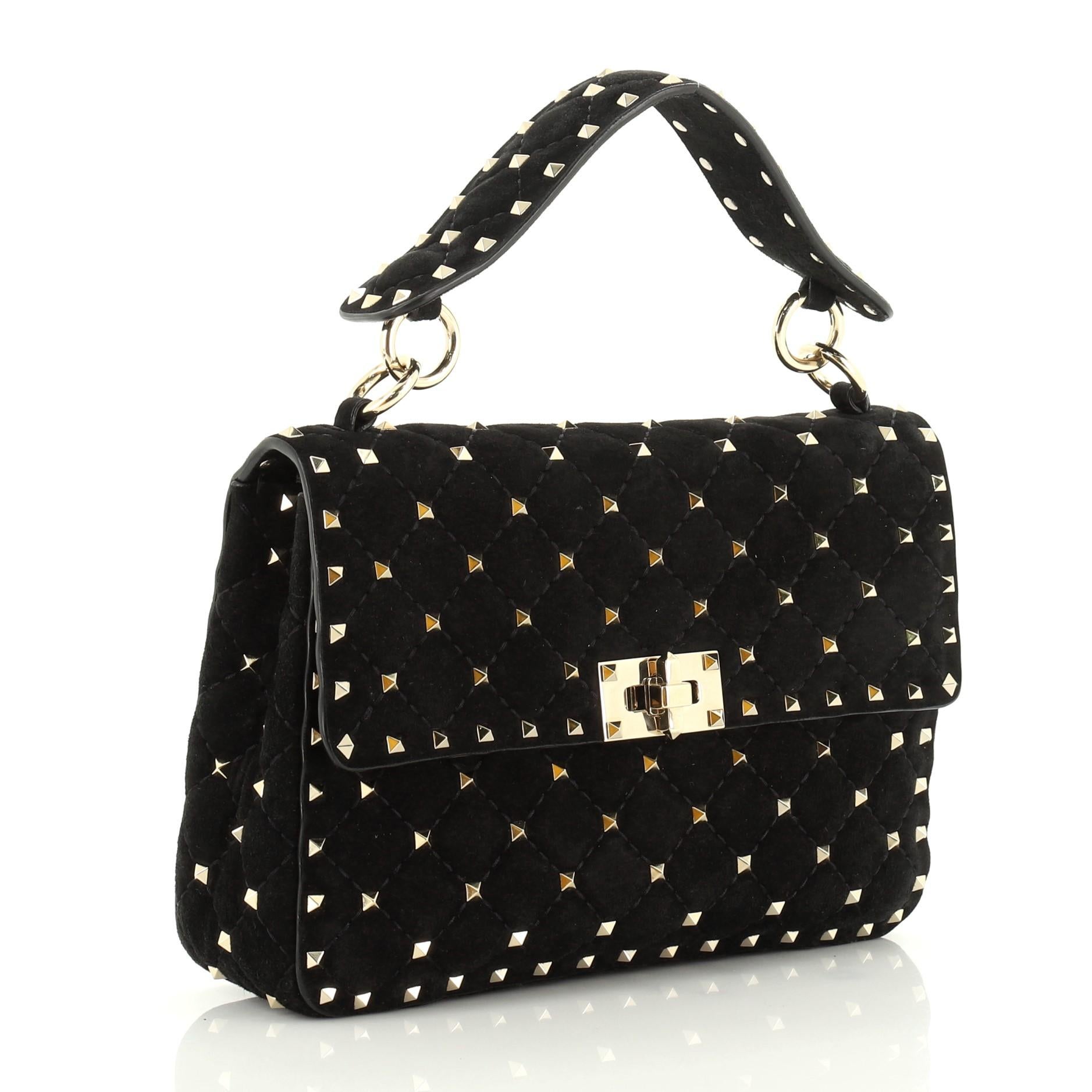 This Valentino Rockstud Spike Flap Bag Quilted Suede Medium, crafted from black suede, features pyramid stud embellishments, top handle with stud detailing, chain-link strap and gold-tone hardware. Its turn-lock closure opens to a black leather