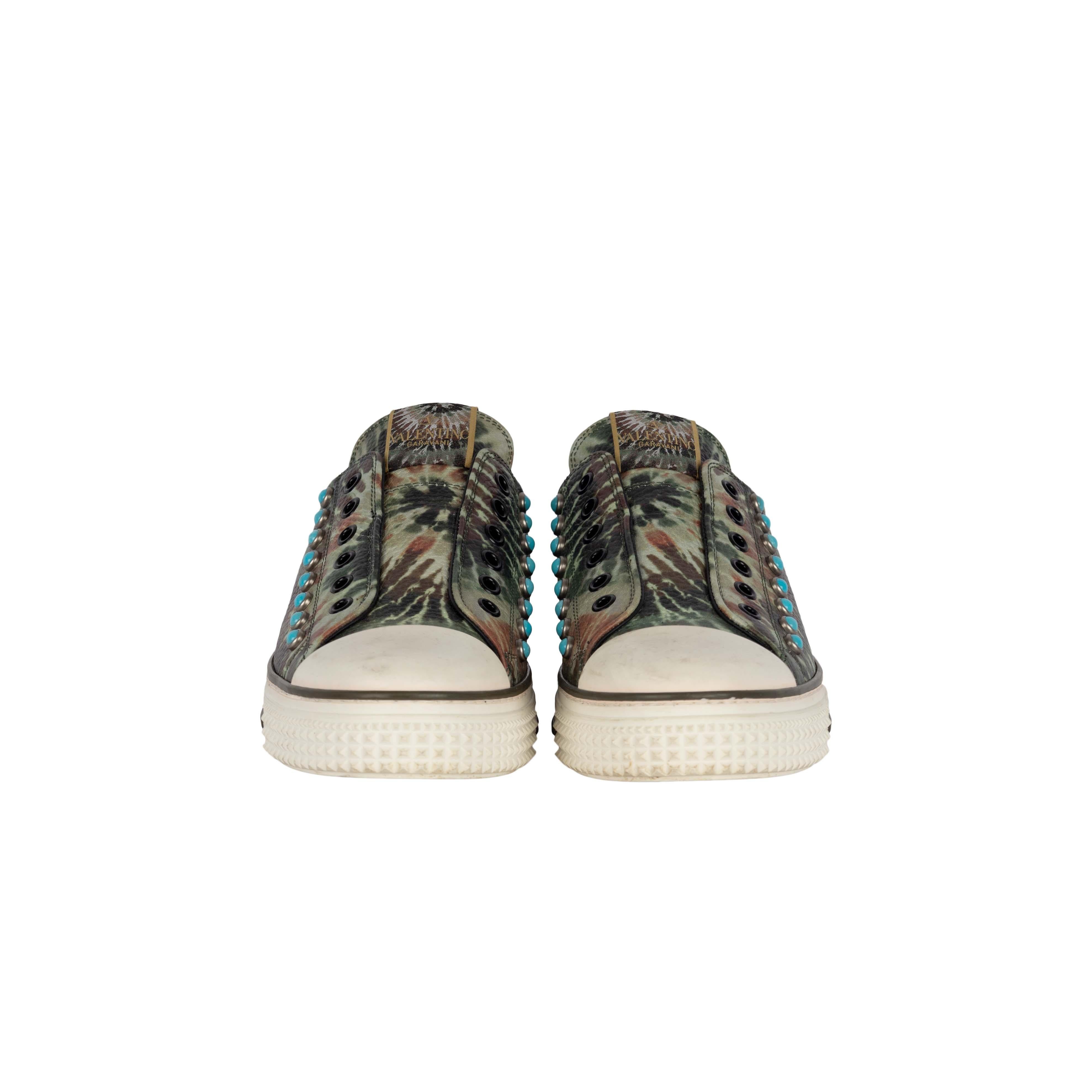 From Valentino's Fall 2016 collection, the Rockstud Tie-dye sneakers differ from your traditional shoe definition with empty eyelets attached to the tongue. The blue studs that are placed strategically on the shoes add a bright color pop to the dull