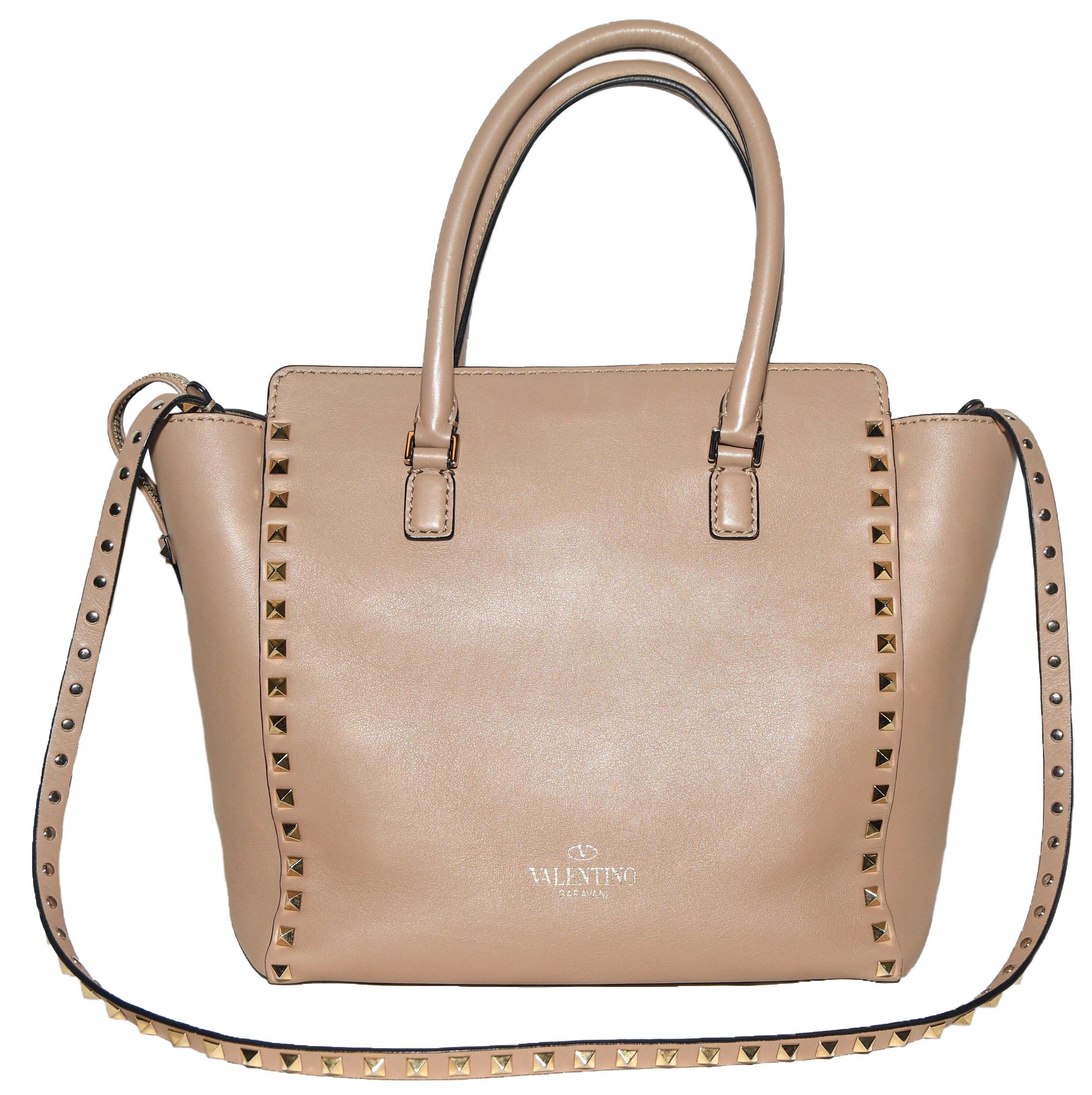 Valentino Rockstud  top handle taupe tote bag is a luxurious rich grained leather crafted by the famous Italian house of Valentino.  This bag is accentuated with the rose color pyramid shape Rockstuds.  For closure, at front,  a push lock fastener. 