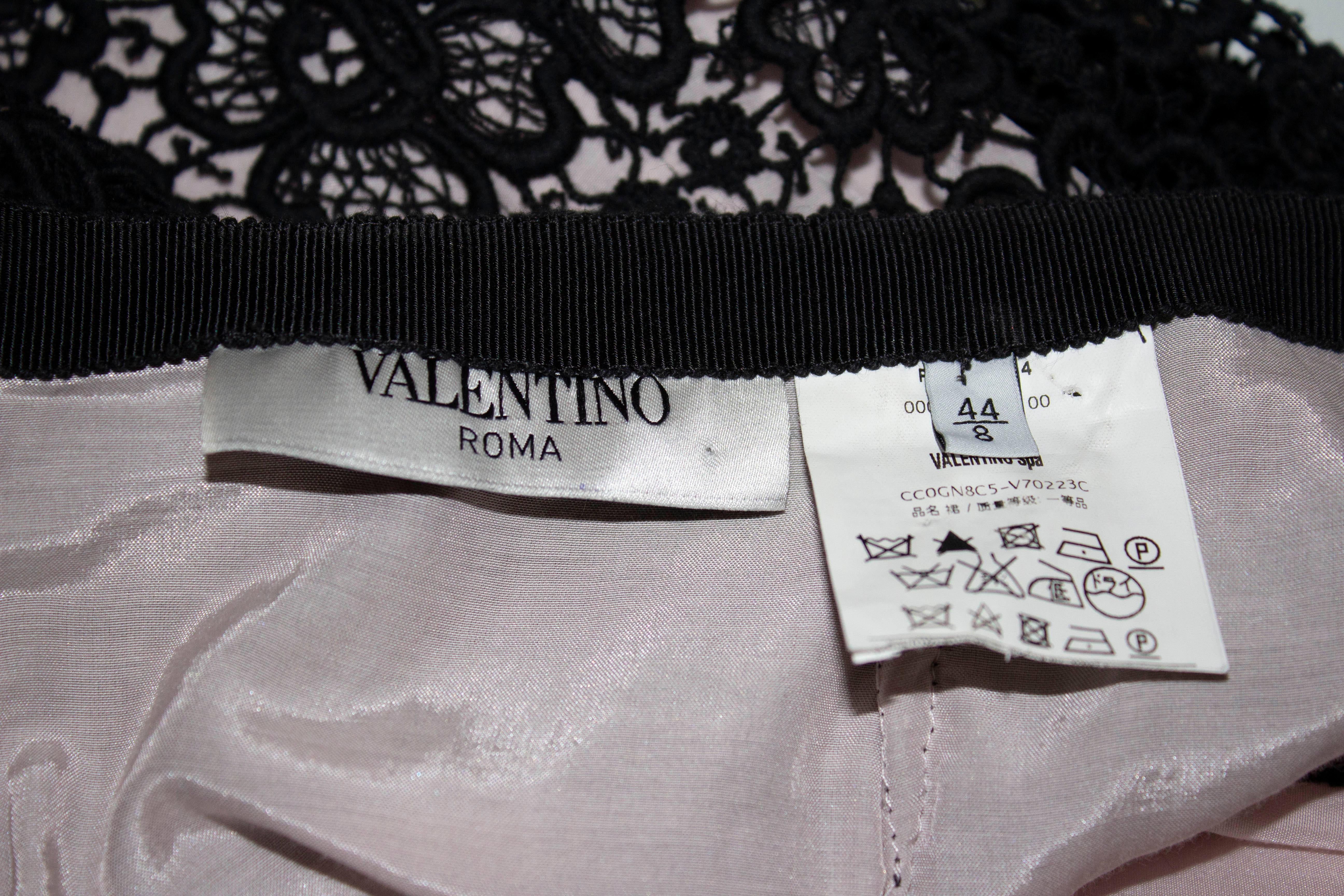 A pretty skirt for summer by Valentino Roma. The skirt is in an attractive heavy black lace with a pale pink lining and central back zip opening. Size 44 /8  Measurements: waist 31'',length 21''