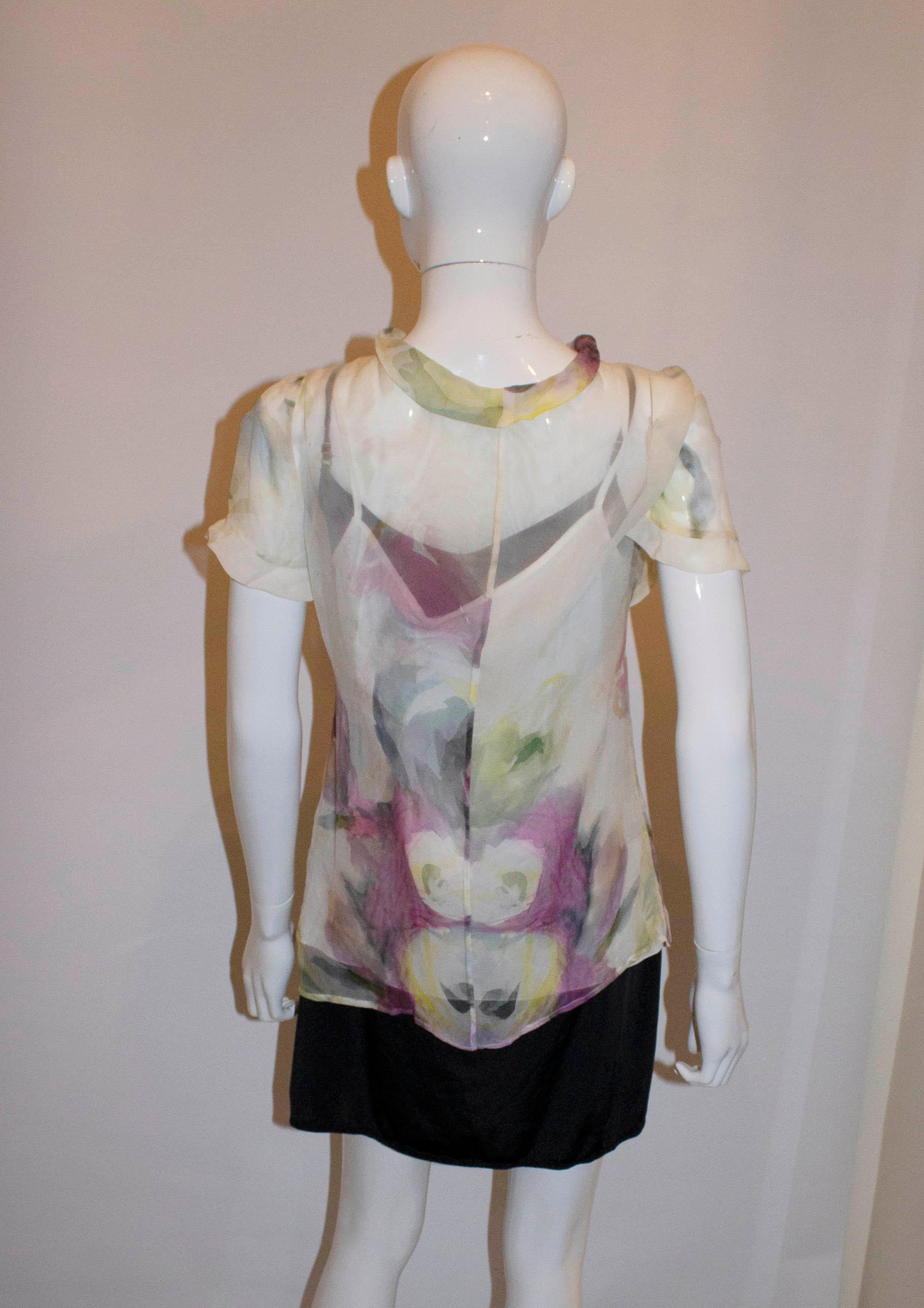 A pretty silk top by Valentino Roma. The shirt has a floral print  with cap sleaves and a button front opening. 
It has a cami top underneath. Size 46 , Measurements Bust 36'', length 26''