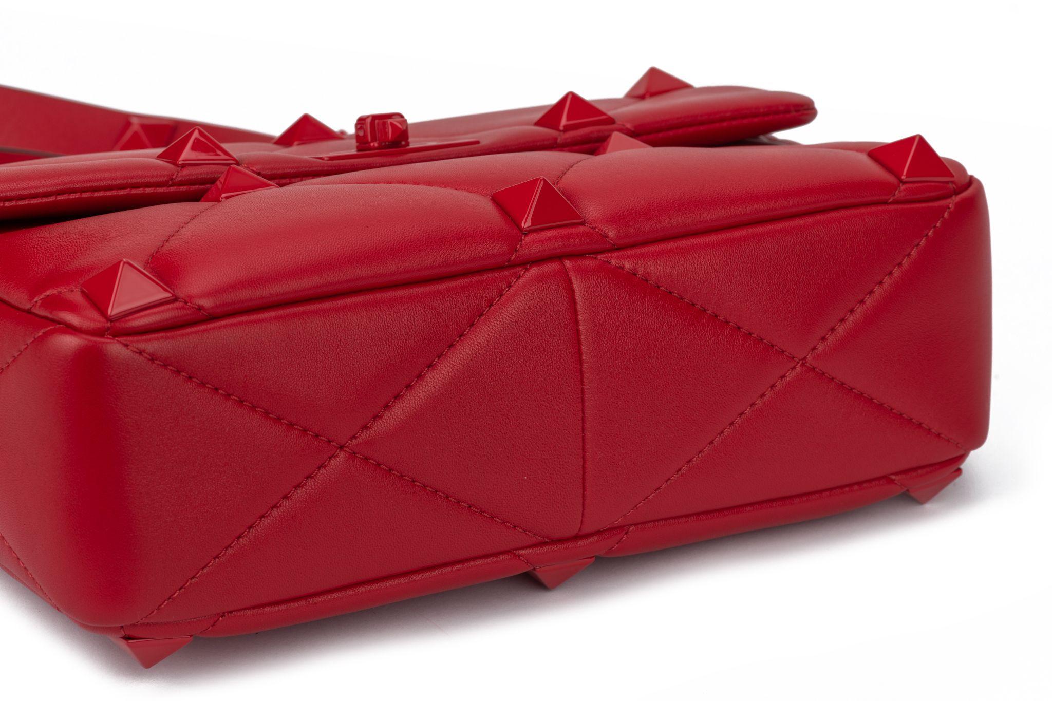 Valentino Roman Stud Collection in red lambskin leather. Diamond-quilted shoulder bag with tonal studs and a versatile top handle and crossbody strap combination. Handle drop 3.5”, detachable shoulder strap 19”. The bag is new and comes with the