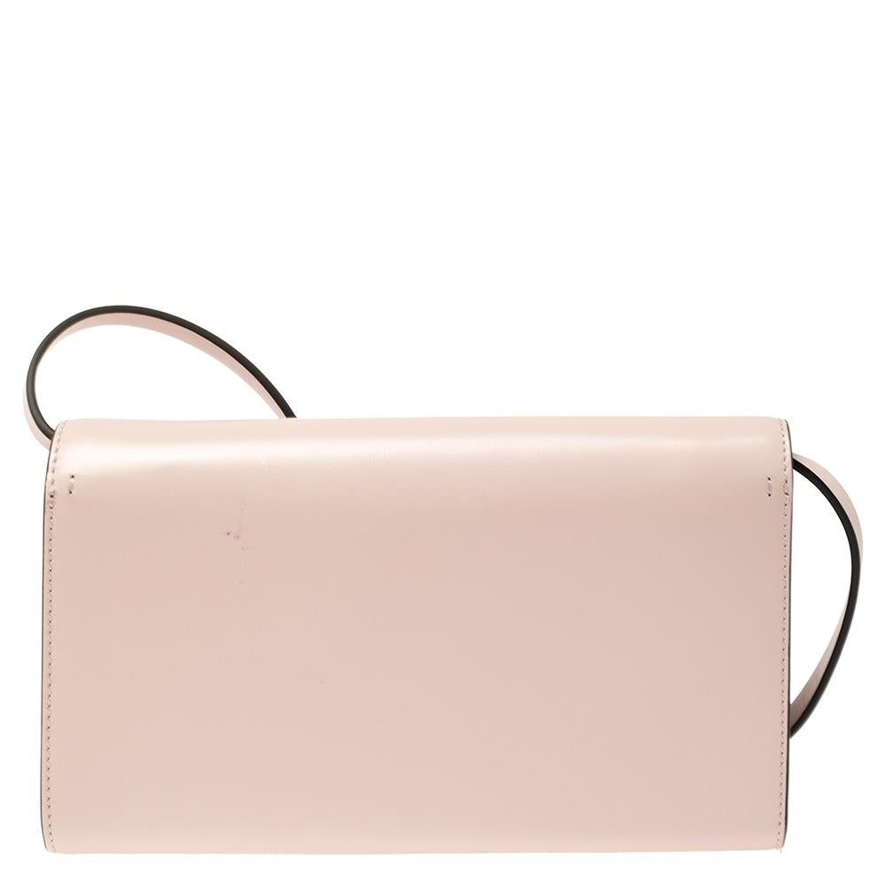 This clutch bag from Valentino represents the label's contemporary and classy attributes. It is made from rose quartz leather featuring the Vlogo adorned with Swarovski crystals on the front flap and an adjustable shoulder strap. Make heads turn