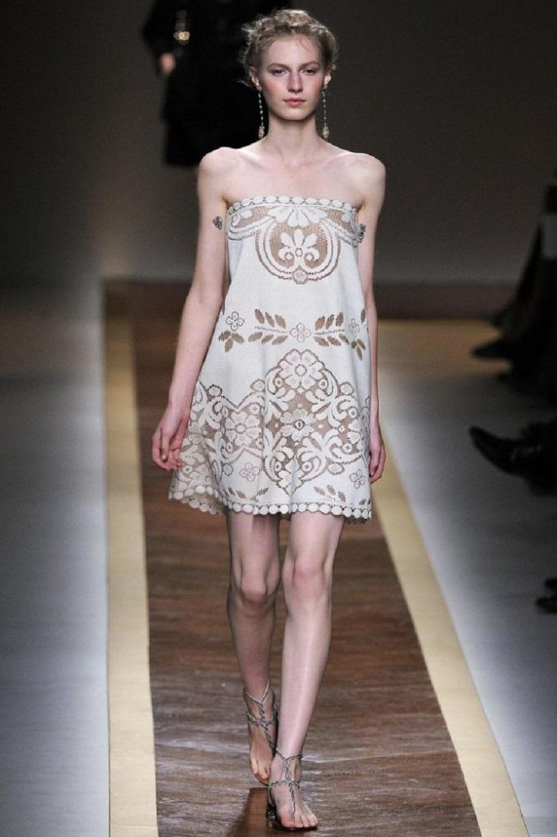 Una estética suave, romántica y de inspiración vintage, típica de la colección Valentino Primavera 2012, diseñada por Maria Grazia Chiuri y Pierpaolo Piccioli.
Esta colección era conocida por su feminidad etérea, con mucho encaje, telas